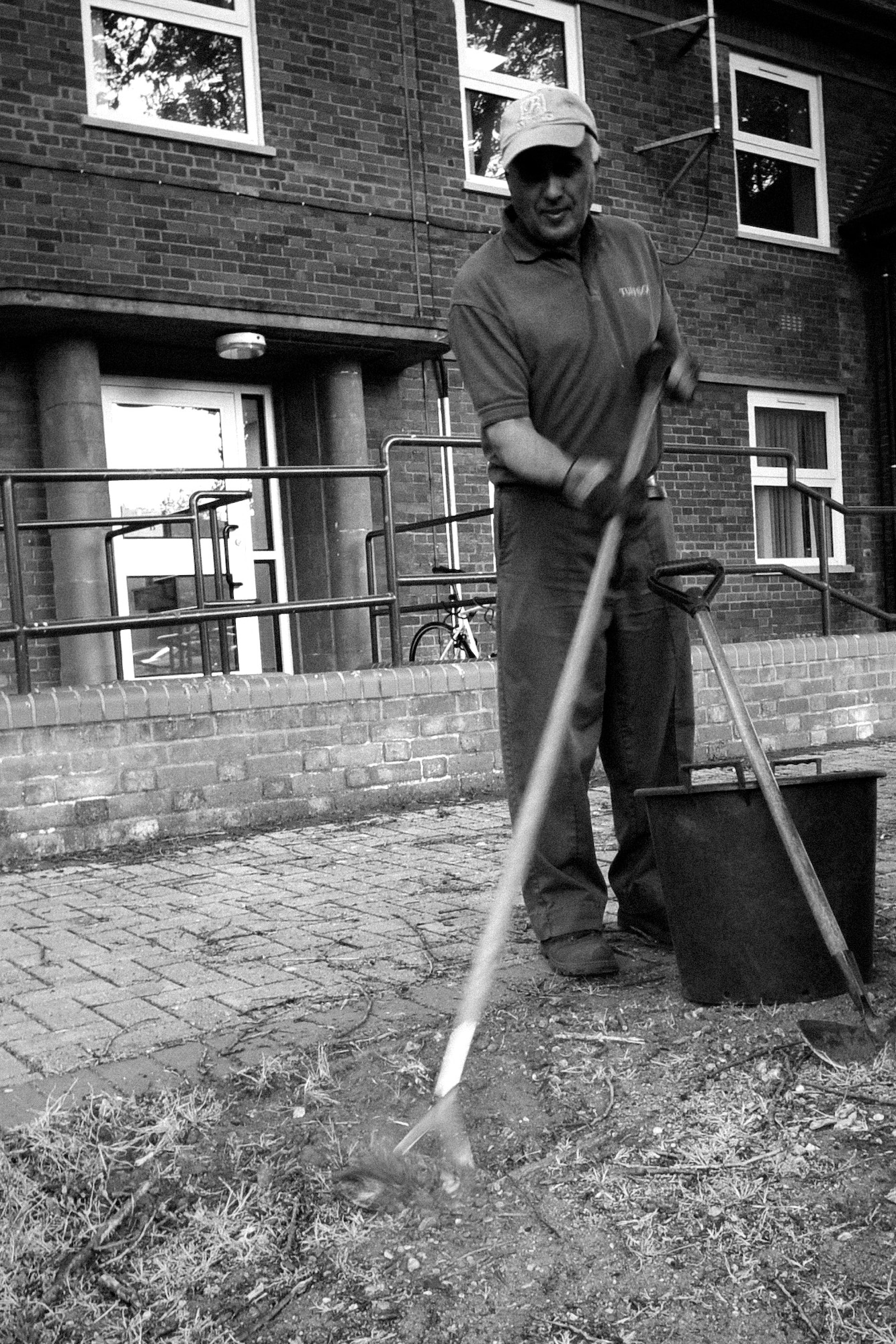 RAF MILDENHALL, England – Ivan Hempstead, a local landscaping contractor, removes grass and weeds outside Building 450 May 18.  With weather getting warmer and longer daylight hours, keeping the base clean and the gardens manicured is more commonly seen around the base.  (U.S. Air Force photo/Staff Sgt. Christopher L. Ingersoll)