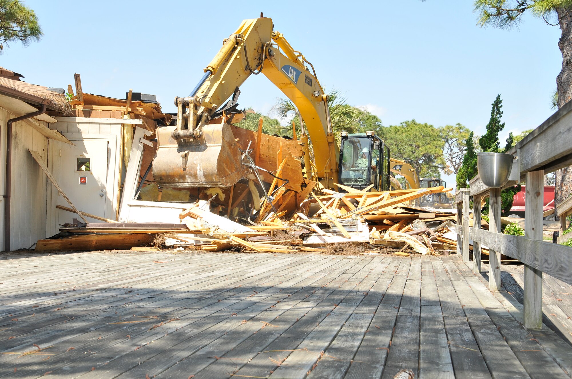 Col. James Browne, 325th Fighter Wing commander, operates a CATERPILLAR 330C Excavator while demolishing an old building at Tyndall Air Force Base May 17.   (U.S. Air Force photo by Lisa Norman)