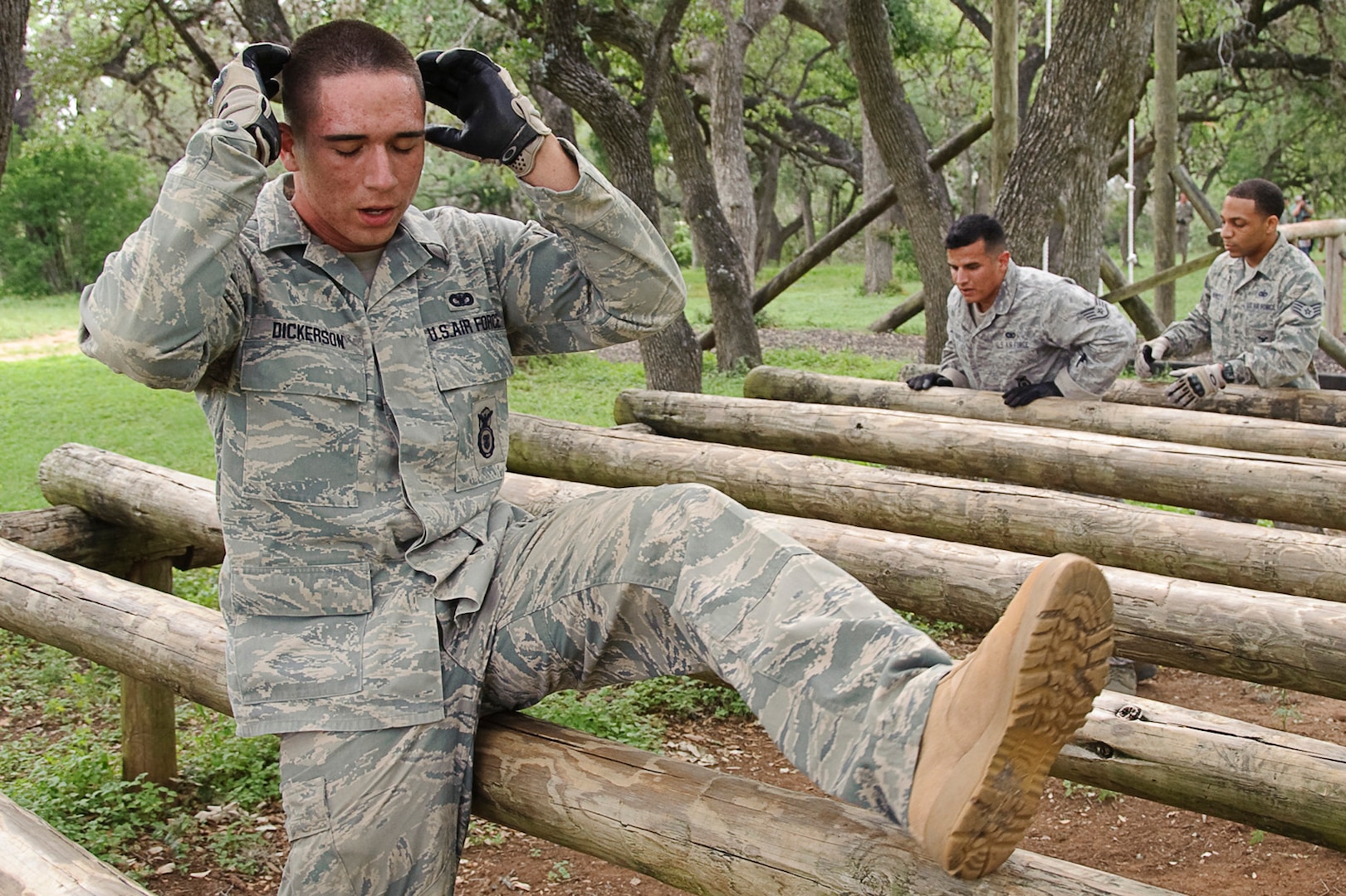 Airman First Class Jonathan Dickerson of the 902nd Security Forces Squadron swings his leg over a waist-high log during the during the obstacle course and ruck march event held during National Police Week at Camp Bullis, Texas. Randolph fielded two teams for the event with A1C Dickerson’s team placing second with a time of 1:07:54. (U.S. Air Force photo/Steve Thurow)