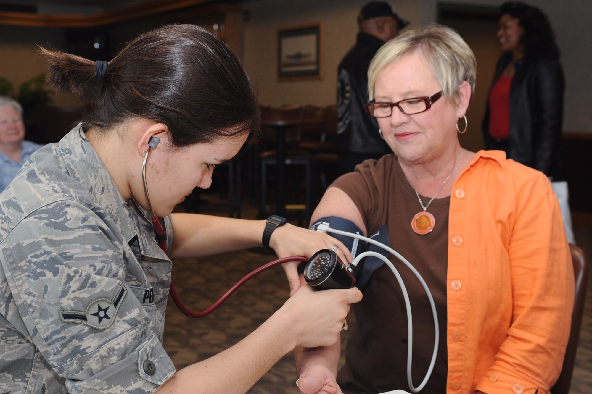 Airman Ilienis Perez, 319th Medical Operations Squadron, checks Dayna Sorby’s pulse May 15, Grand Forks Air Force Base, N.D. Mrs. Sorby attended the Retiree Appreciation Day that was held to support Air Force retirees. (U.S. Air Force photo by Airman 1st Class Amber Price)