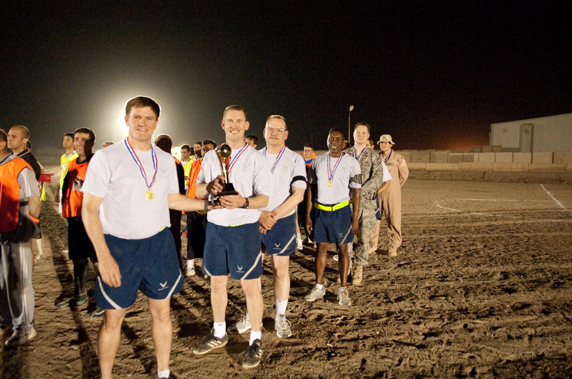 Members of the 321st Air Expeditionary Wing, Iraq Training Advisory Mission-Air Force proudly accept their third place trophy held by Iraqi Air Force during a football or soccer tournament, at New Al Muthana Air Base, Iraq May 17, 2010. The tournament promotes camaraderie, sportsmanship and building partnerships among coalition forces. (U.S. Air Force photo by Senior Master Sgt. Elizabeth Gilbert/released)