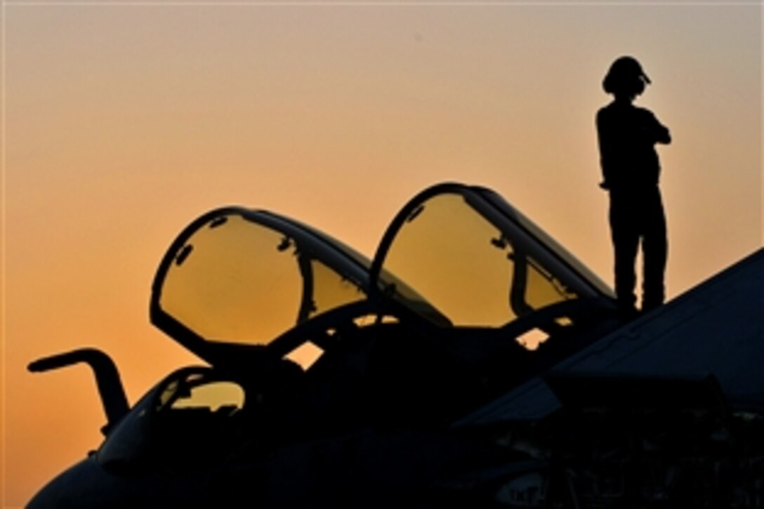 A sailor watches the sunset on top of an EA-6B Prowler aboard the aircraft carrier USS Dwight D. Eisenhower in the Arabian Sea, May 14, 2010. The Eisenhower Carrier Strike Group is deployed as part of an ongoing rotation of forward-deployed forces to support maritime security operations in the U.S. 5th Fleet area of responsibility. assigned to the Patriots of Electronic Attack Squadron 140.
