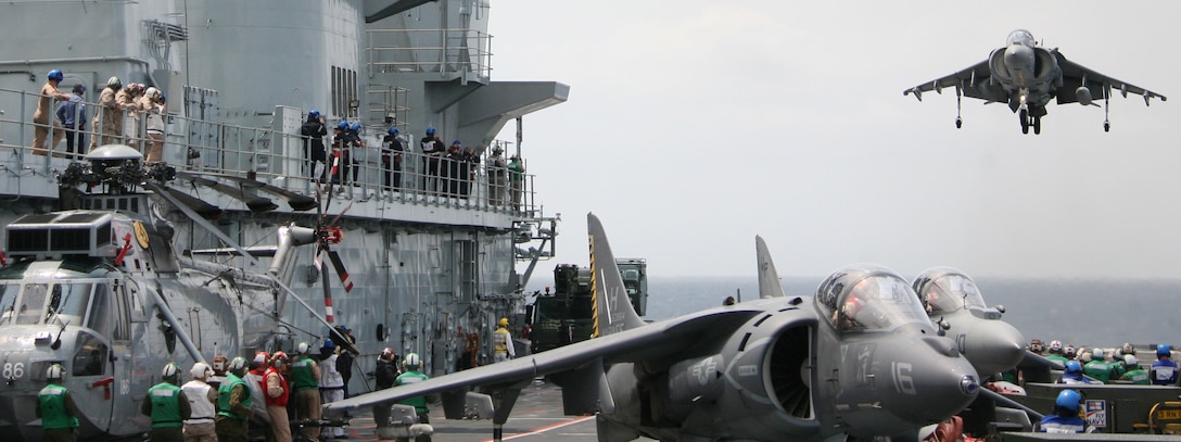 An AV-8B Harrier vertically lands onto the HMS Ark Royal, the British Royal Navy's flagship aircraft carrier, May 19, 2010, as part of Capella Strike, a multinational training evolution with British counterparts.::r::::n::"The exercise was an opportunity for both nations to display their capabilities and find ways to integrate them," said Capt. Christopher E. Brandt, Marine Attack Squadron 223 administration officer.