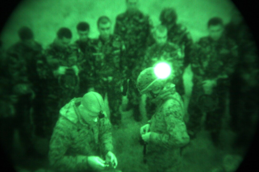 Lance Cpls. Joel Hindman, left, and David Johnson, both assaultmen with scout platoon, Headquarters and Service Company, 1st Tank Battalion, issue night vision goggles to Romanian Marines and soldiers during a night vision familiarization exercise at Babadag Training Area, Romania, May 19. 1st Tank Battalion is deployed to the Black Sea as the core of a Security Cooperation Marine Air-Ground Task Force with the mission to promote regional stability and build the partner nations’ military capacity.