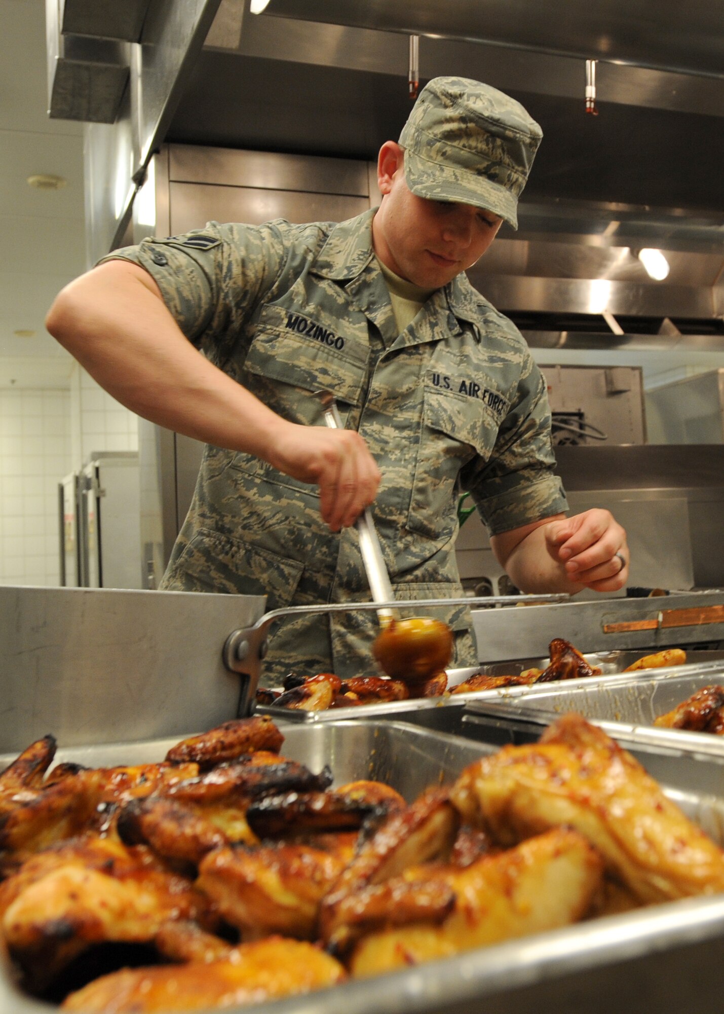 Airman 1st Class Michael Mozingo, 22nd Force Support Squadron chef, prepares chicken for the lunch in the dining facility May 19, 2010, McConnell Air Force Base, Kan.  McConnell’s dining facility is still serving meals during regular hours during an operational readiness exercise.  The DFAC serves active duty members, Reserve and Guard members and service members from sister branches authorized to eat there. (U.S. Air Force photo/Airman 1st Class Andrea Salazar)
