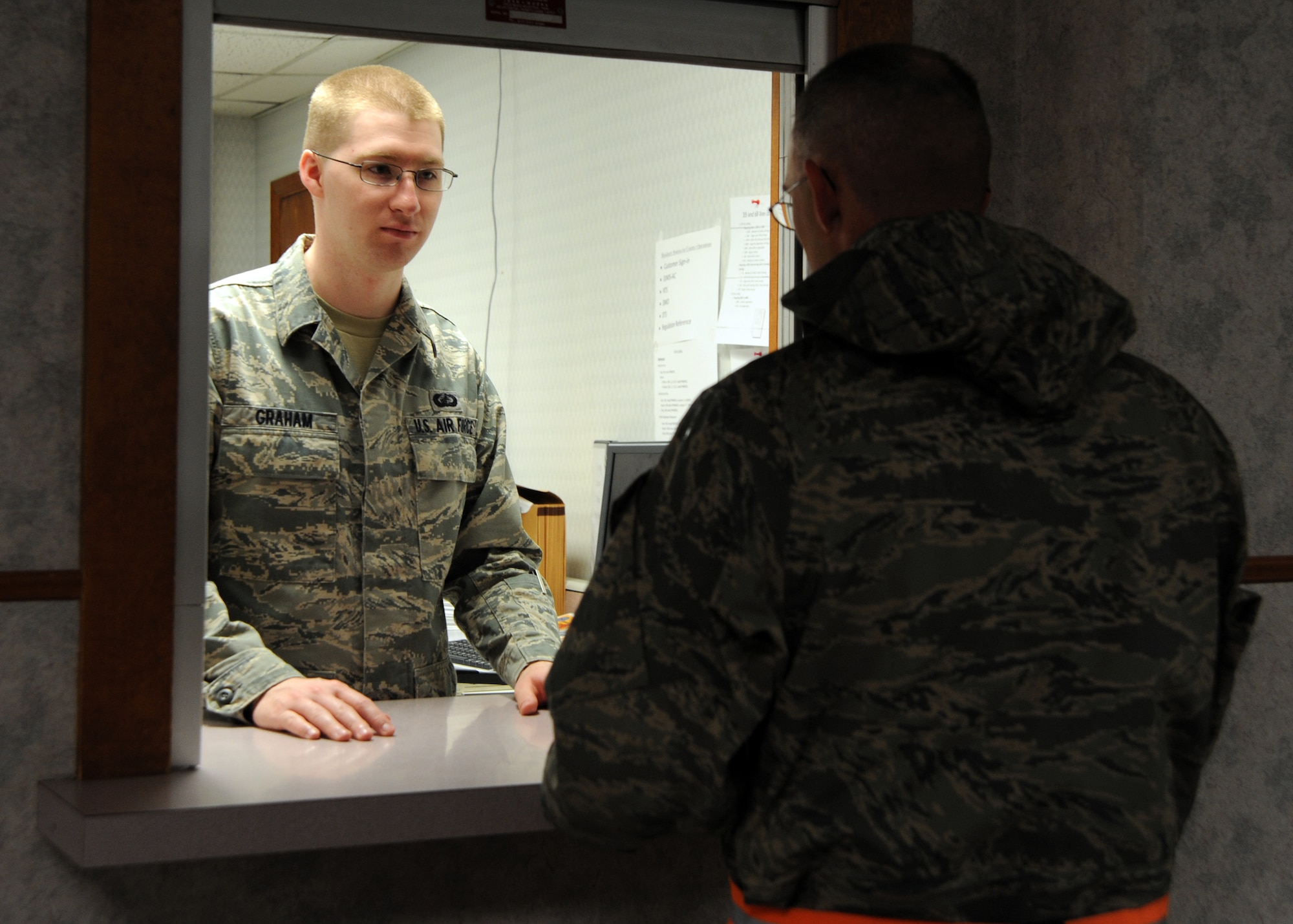 Airman 1st Class Sean Graham, 22nd Comptroller Squadron financial management technician, assists Staff Sgt. Raymond Oliver, 22nd Civil Engineering Squadron water and fuels systems maintenance craftsman, with questions about permanent change of duty station May 19, 2010, McConnell Air Force Base, Kan.  McConnell’s Finance conducted 24-hour operations during an operational readiness exercise May 18 to 20. McConnell’s wing exercise plans and programs office coordinates wing exercises to keep Team McConnell Airmen ready for combat operations. (U.S. Air Force photo/Airman 1st Class Andrea Salazar)