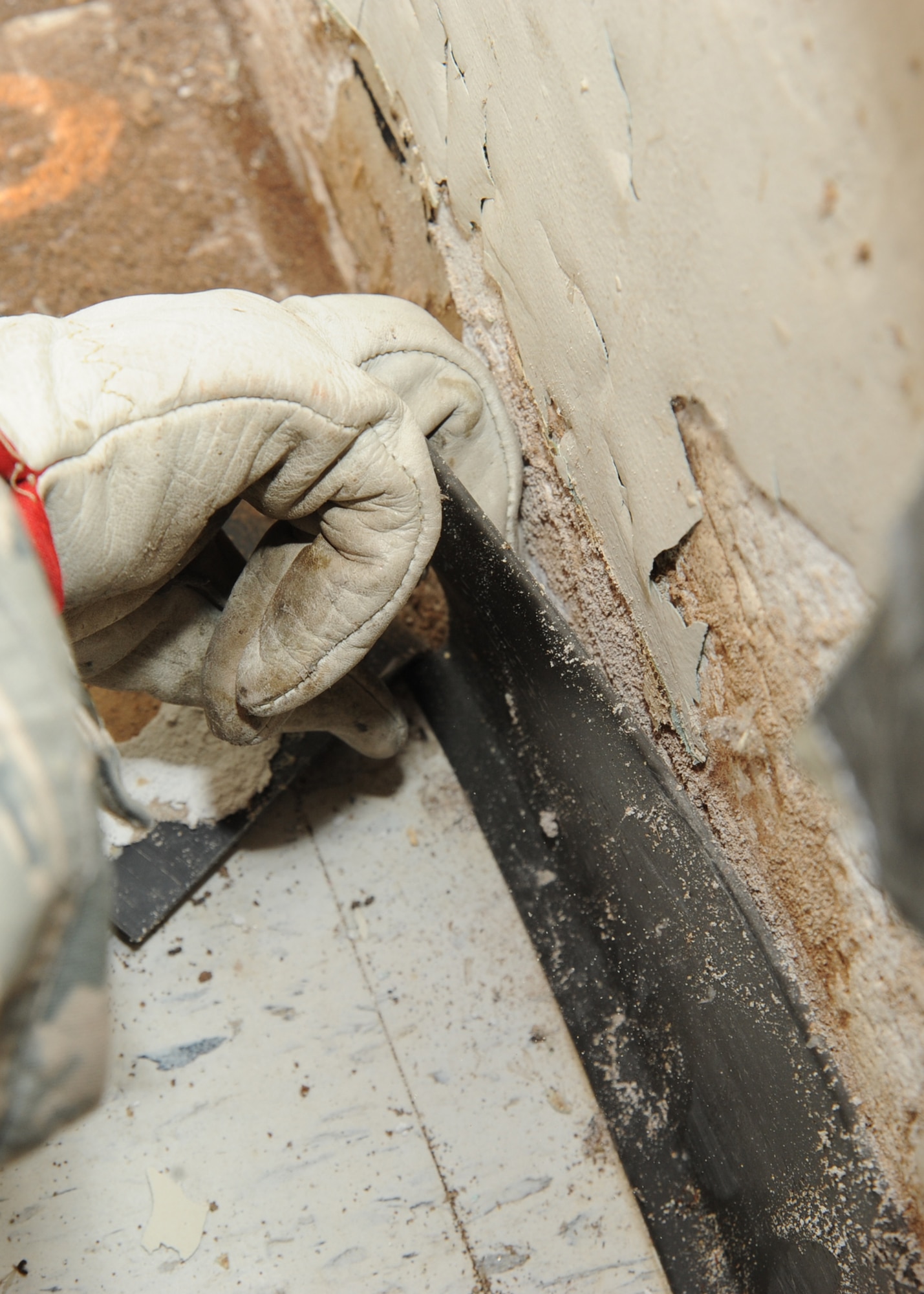 Staff Sgt. Kahlila Mutidi, 22nd Civil Engineer Squadron pest management journeyman, uncovers termite holes in a wall at the 184th Medical Group Services Flight building April 14, 2010, McConnell Air Force Base, Kan.  During termite treatment, the pest management office uses a chemical foam agent that expands ten times its projected beginning dose, reaching hard to find areas within the walls of a structure.  Each 0.9 ounce treatment can treat approximately 1,000 cubic inches. (U.S. Air Force photo/Senior Airman Maria Ruiz)