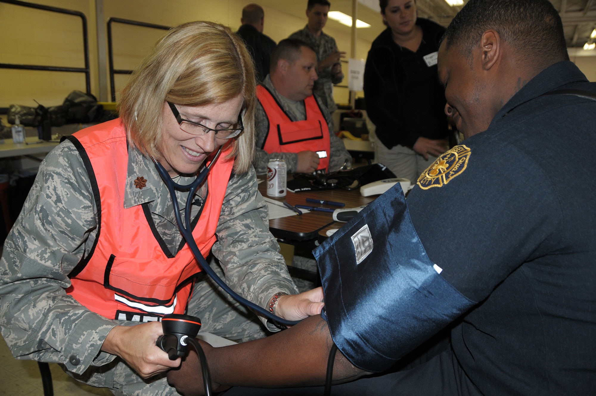 Major Julie Carpenter, Medical (Chemical, Biological, Radiological, Nuclear, or Explosive) Enhanced Response Force, conducts a preliminary health assessment on a firefighter from the Jersey City Hazmat Team, Jersey City Fire Department, N.J., before he conducts field operations and recovery during the Regional Mass Fatality Management Training Evolution on May 11, 2010 at the U.S. Army Reserve Center/Jersey City Police Facility in Jersey City, N.J.  The RMFMTE focuses on fatality management techniques and procedures and assists in the development of local and regionalized response plans for response to a mass fatality event resulting from terrorist attacks or natural disasters.  The week long joint training effort include the Air National Guard, Department of Homeland Security, New York City Office of Chief Medical Examiner, along with numerous medical examiners/coroners, fire departments, law enforcement, and other federal and local agencies from the New York, New Jersey, Connecticut, and Pennsylvania.  (U.S. Air Force photo by Master Sgt. Jerry Bynum/Released)