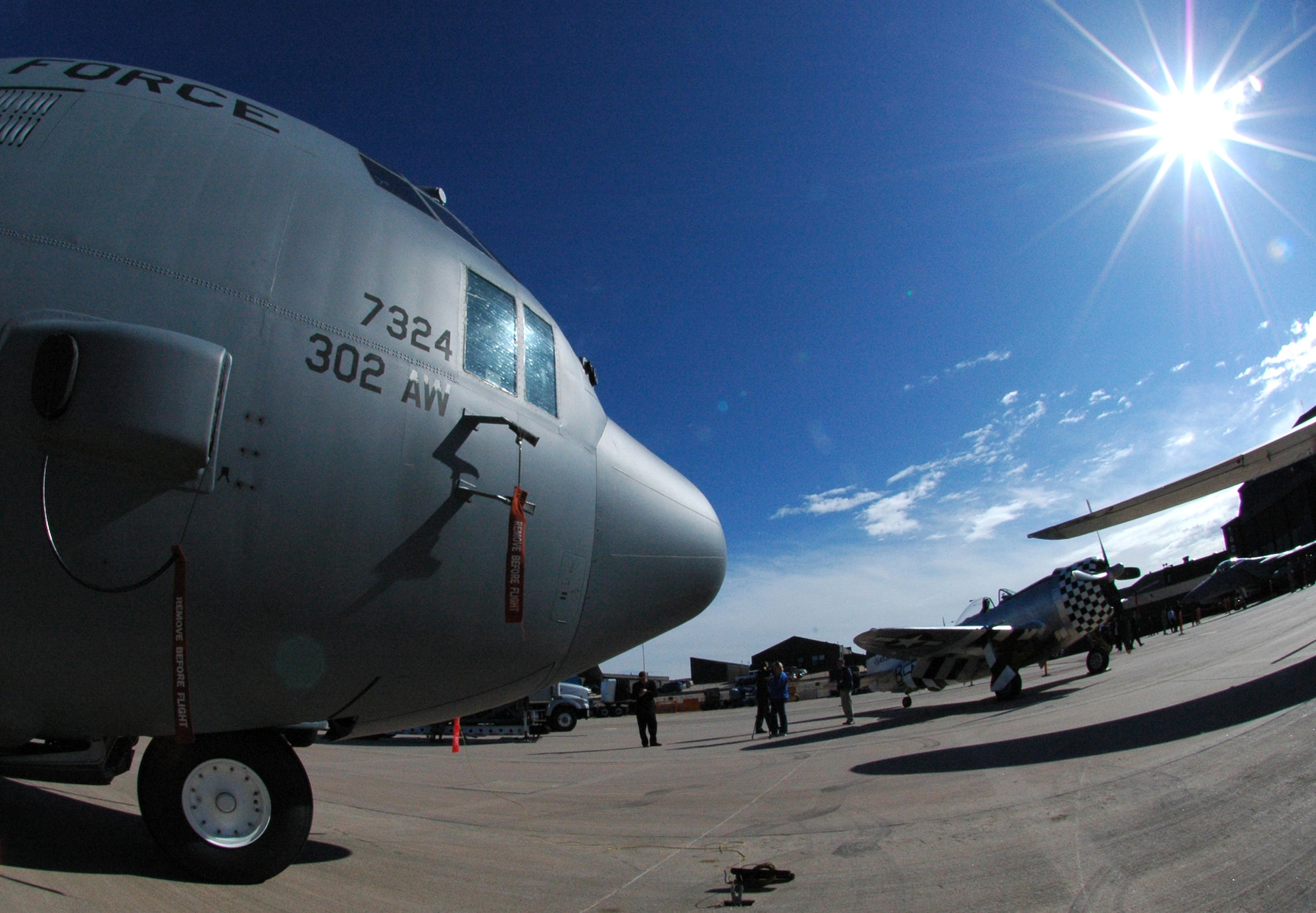Media from the Colorado Springs, Colo., area capture footage May 19 while a 302nd Airlift Wing-assigned C-130 Hercules sits next to a World War II-era P-47 Thunderbolt (right) at Peterson Air Force Base, Colo. The aircraft were joined by a B-25 Mitchell bomber, an F-15C Eagle, a Colorado Air National Guard F-16 Fighting Falcon and a Canadian CF-18 Hornet as part of a change of command ceremony for the North American Aerospace Defense Command and U.S. Northern Command organizations. The 302nd Airlift Wing is an Air Force Reserve Command-assigned unit. (U.S. Air Force photo/Staff Sgt. Stephen J. Collier)