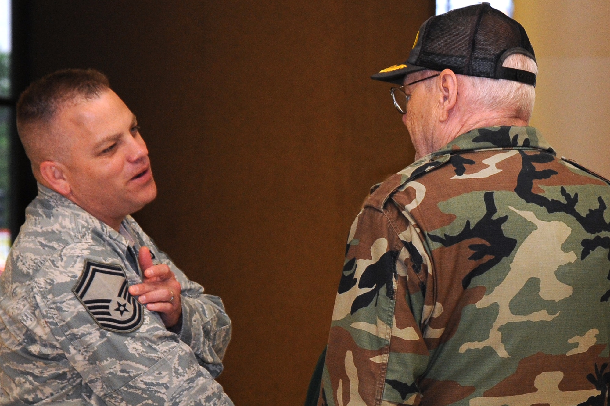 Senior Master Sgt. Timothy Miller, 22nd Operation Support Squadron aircrew flight equipment superintendent, explains the rank insignia to Daniel MacMartin, a former Airman, May 14, 2010 at Century II in downtown Wichita, Kan.  The Air Force enlisted rank insignia has evolved many times since becoming an independent service in 1947.  McConnell Air Force Base has more than 2,300 enlisted members assigned who support the largest KC-135 Stratotanker base in Air Mobility Command. (U.S. Air Force photo/Tech. Sgt. Chyrece Campbell)