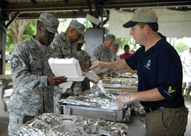 Chief Master Sgt. Denny Heitman serves Senior Master Sgt. Sean Early a scoop of coleslaw at the Annual Chief's Fish Fry May 14, 2010 at the Joint Base Charleston picnic grounds. The fish fry began as a barbeque in 1987 as a way to unite the reserve and active-duty members of Charleston AFB. Chief Heitman is a fire chief with the 628th Civil Engineer Squadron and Sergeant Early is with the 437th Maintenance Squadron. (U.S. Air Force photo/Airman 1st Class Lauren Main)