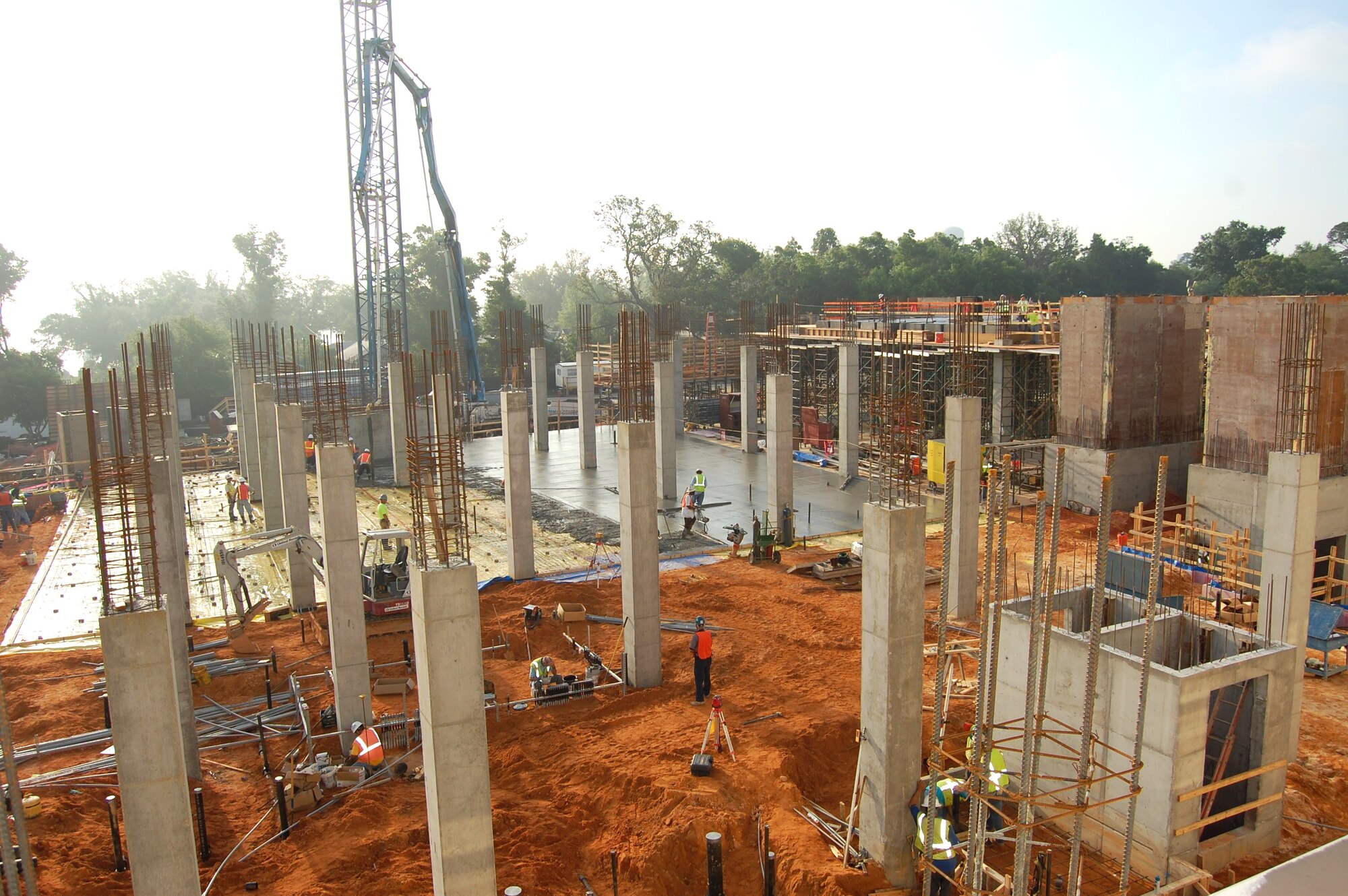 W.G. Yates and Sons Construction Company workers, center background, pour and smooth concrete to make the first floor of the 81st Medical Group Hospital’s new inpatient tower May 6 while others, right, install construction forms for the  second story floor.  Others in the foreground prepare another portion of the first floor for concrete to be poured.  The enclosed areas at right are elevator shafts. The tower is scheduled to be completed in September 2011.  (U.S. Air Force photo by Steve Pivnick)