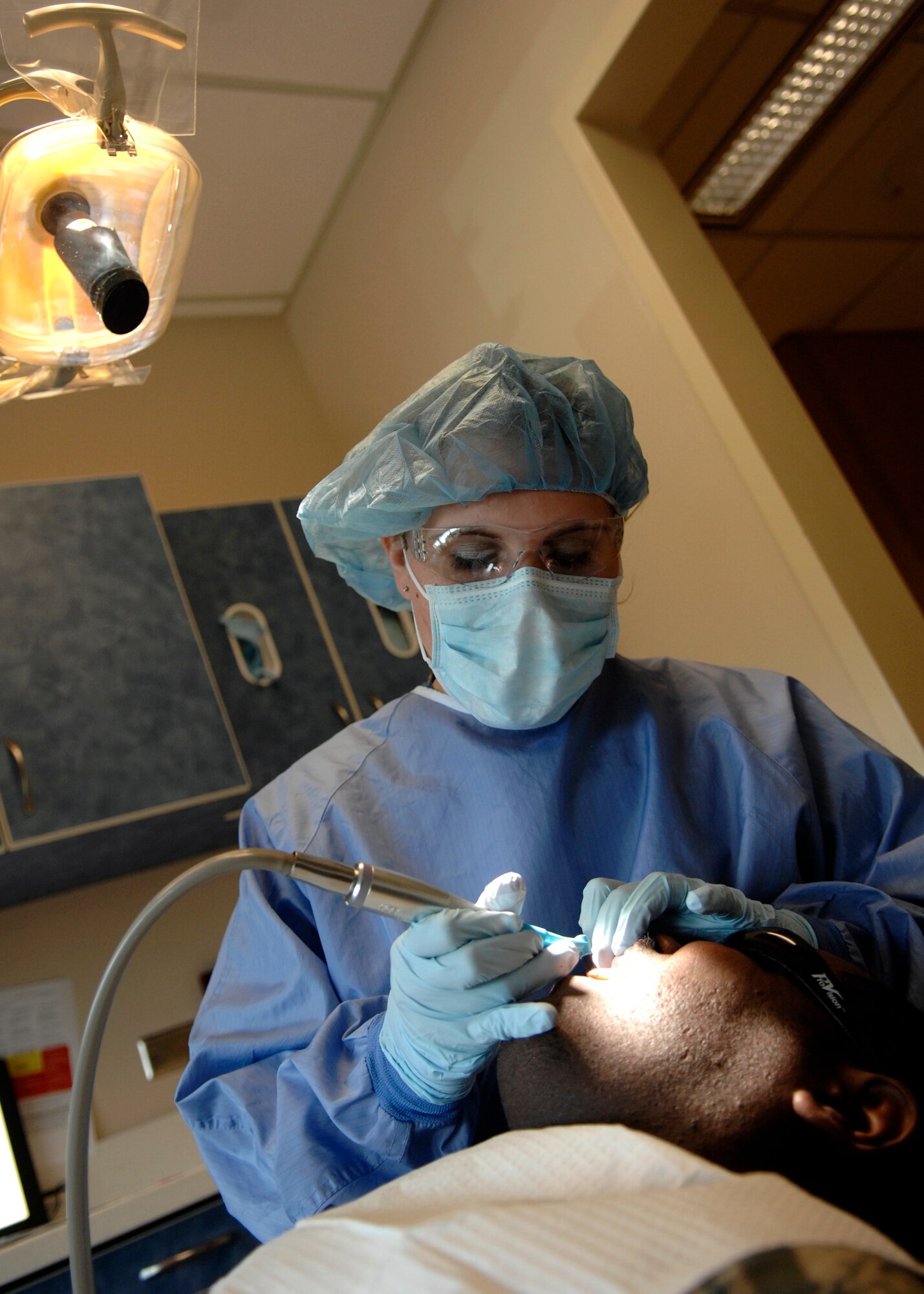 Senior Airman Stephanie Rowe polishes a patient's teeth using prophylaxis May 19, 2010, at the dental clinic on Joint Base Charleston, S.C. After the cleaning is done and tartar is removed from the teeth, the dental assistant then polishes the surface of the teeth using a using a gritty, tootpaste-like material. Senior Airman  Rowe is a dental assistant with the 628th Medical Group. (U.S. Air Force photo/Senior Airman Timothy Taylor)