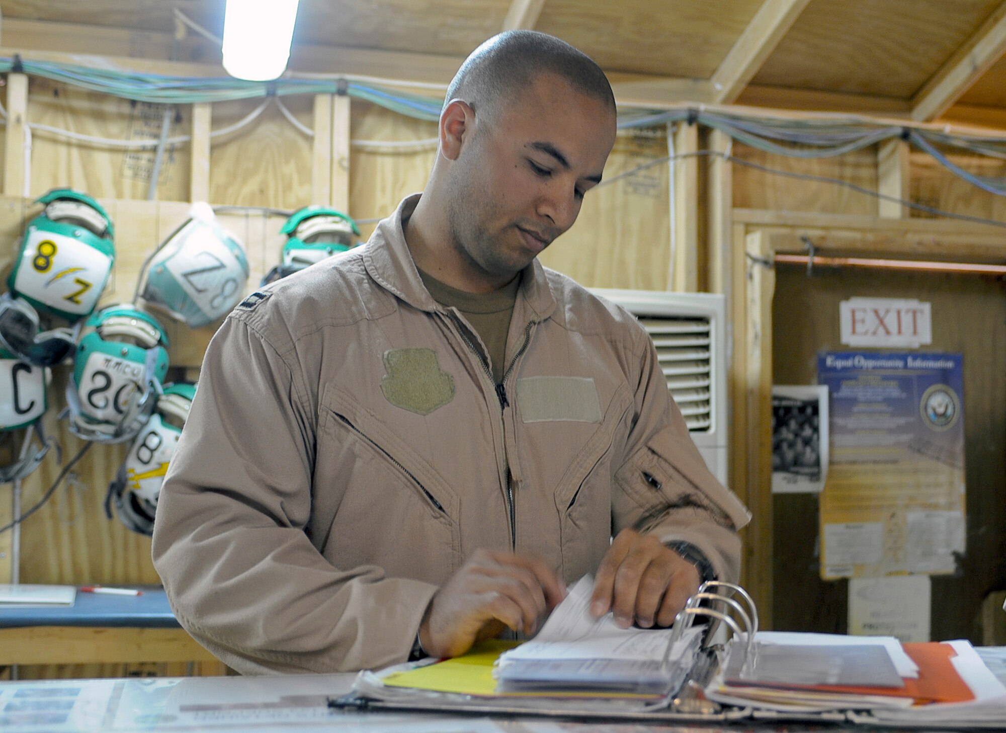 Capt. Jason Constantine looks through the maintenance book prior to a mission launch April 29, 2010, at Al Asad Airfield, Iraq. Captain Constantine is one of four Air Force electronic warfare officers flying with Navy personnel on the A6B-Prowler to conduct aerial over watch operations for convoys at Al Asad. The Air Force officers are assigned to the 366th Fighter Wing at Mountain Home Air Force Base, Idaho, and work with their counterparts at Naval Air Station Whidbey Island, Wash., in the 388th Electronic Combat Squadron. Captain Constantine is an electronic warfare officer with the Navy's VAQ133 Electronic Attack Squadron. (U.S. Air Force photo/Master Sgt. Linda C. Miller)