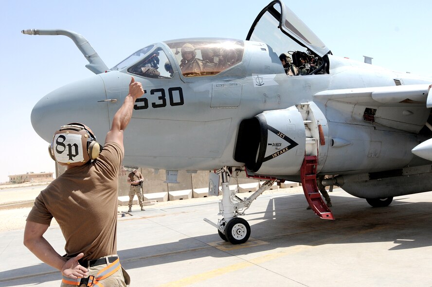 Navy maintenance crews signal the pilot during pre-flight checks as an A6B-Prowler with the Navy's Electronic Attack Squadron 133 prepares to launch April 29, 2010, at Al Asad Airfield, Iraq. The Navy land-based squadron is one of three currently flying the A6B with Air Force electronic warfare officers. The joint warfighters are conducting aerial overwatch operations for convoys at Al Asad. The Air Force officers are assigned to the 366th Fighter Wing at Mountain Home Air Force Base, Idaho, and work with their counterparts at Naval Air Station Whidbey Island, Wash., in the 388th Electronic Combat Squadron. (U.S. Air Force photo/Master Sgt. Linda C. Miller)