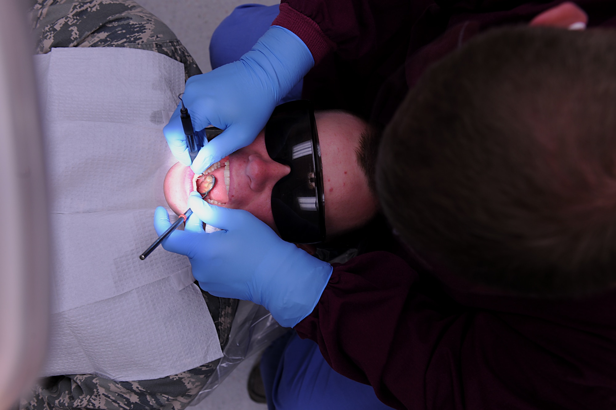 MOODY AIR FORCE BASE, Ga. -- Staff Sgt. Steven Smith, 23rd Aeromedical Dental Squadron dental technician, uses a dental mirror and dental probe for a routine dental cleaning on Airman 1st Class Edward Huffman, 822nd Security Forces Squadron member, here May 12. The dental mirror is used to separate the cheeks permitting the technician to see inside of the oral cavity, while the dental probe explores the holes, grooves and fissures of tooth surfaces to locate cavities. (U.S. Air Force photo by Airman 1st Class Joshua Green/RELEASED)