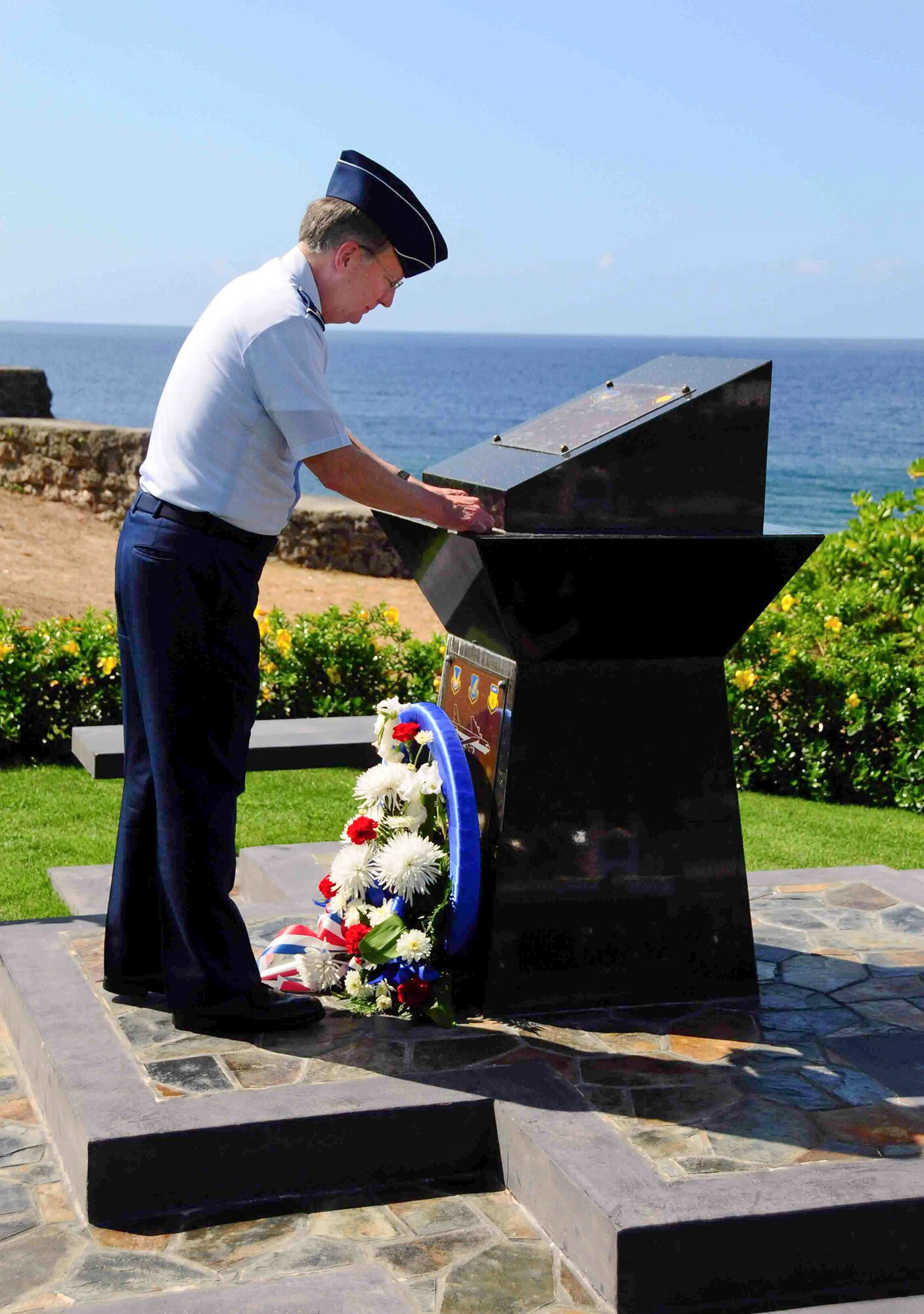 Lt. Gen. Frank G. Klotz places his "commander's coin" on the memorial to RAIDR 21 May 14, 2010, in Agana, Guam, after laying a wreath at the site commemorating the B-52 crew that was lost when their B-52 went down in the Pacific on Guam's Liberation Day on July 21, 2008. General Klotz is the commander of Air Force Global Strike Command. (U.S. Air Force photo/Airman 1st Class Jeffrey Schultze)