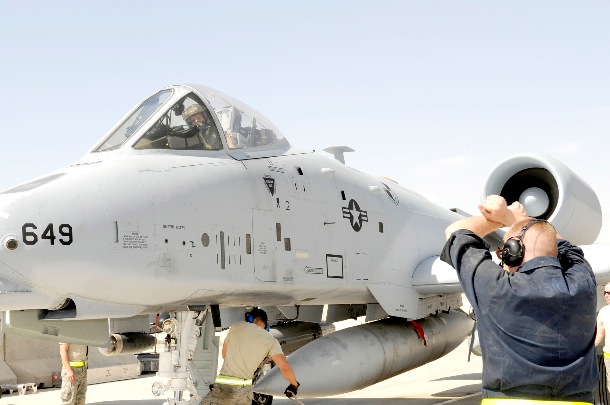 A crew chief gives a signal for the A-10 Thunderbolt II pilot to hold his position as the chocks are put in place May 11, 2010, at Kandahar Airfield, Afghanistan.  (U.S. Air Force photo/Senior Airman Nancy Hooks)
