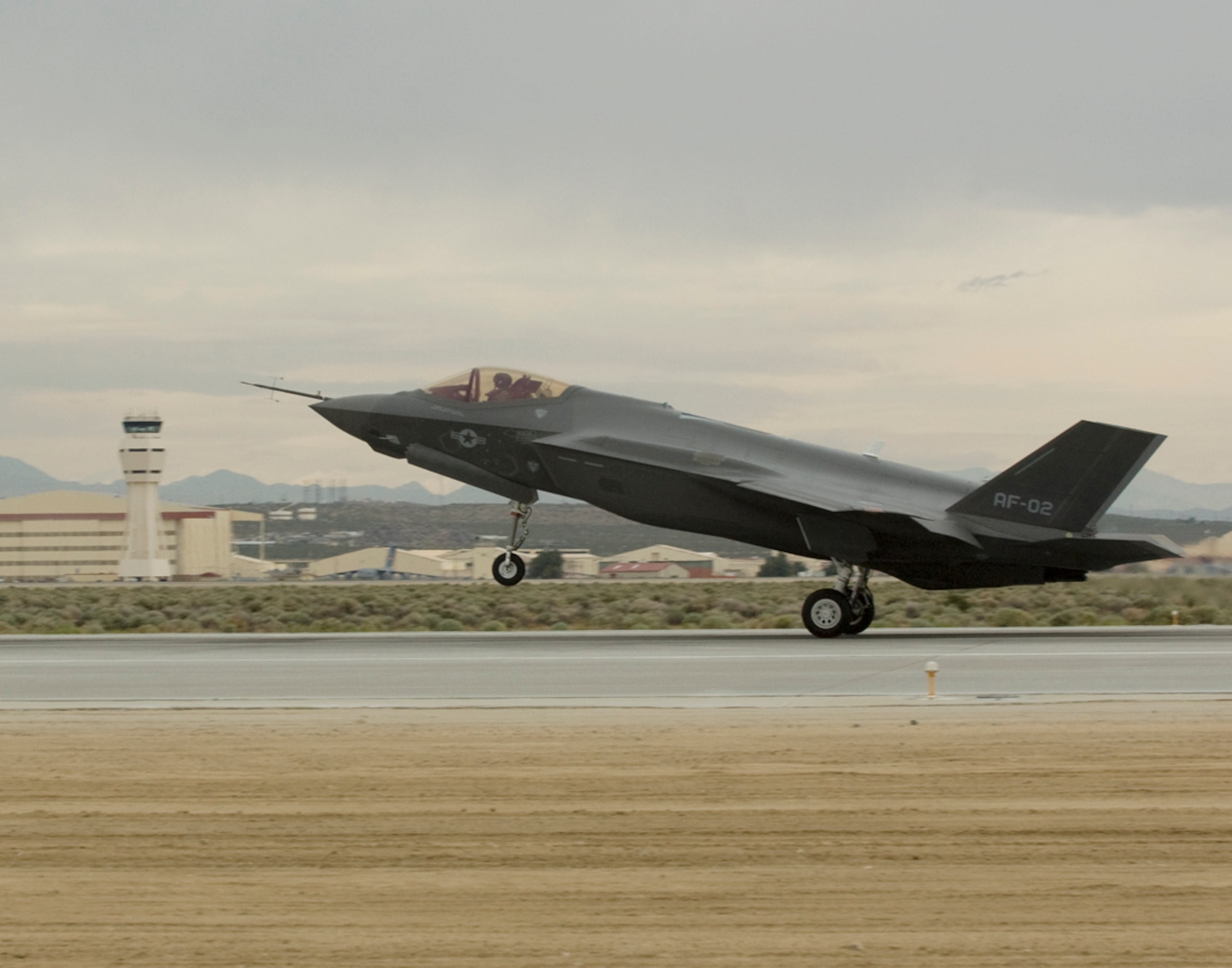 Under cloudy skies and brisk winds, a croud of approximately 200 Joint Strike Fighter project members, family members and visitors gathered as two F-35A Lightning II stealth Joint Strike Fighters arrived at Edwards Air Force Base, Calif., the afternoon of May 17.  The two F-35s will call Edwards their home and be joined by other F-35s in the future.  Here, AF-02, piloted by Mr. John Beasley, Lockhead-Martin chief test pilot, touches down on Runway 22 Left at Edwards.  The two aircraft are assigned to 412th Flight Test Wing, 461st Flight Test Squadron.  (Official U.S. Air Force photograph)