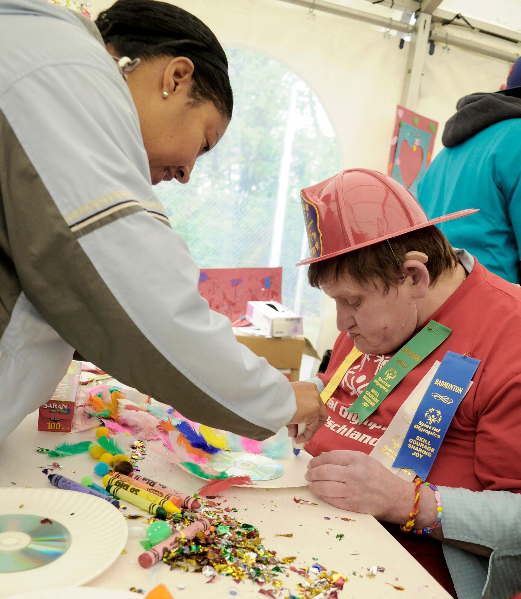 Tammie Honore assists an athlete in an arts and crafts section May 12, 2010, during the Special Olympics in Enkenbach-Alsenborn, Germany. The Special Olympics is a worldwide event for children and adults with disabilities to build confidence and foster friendship. The Kaiserslautern Military Community hosted its 27th Annual Special Olympics for more than 800 athletes. Ms. Honore is a Ramstein Middle School teacher.  (U.S. Air Force photo/Airman 1st Class Brittany Perry)