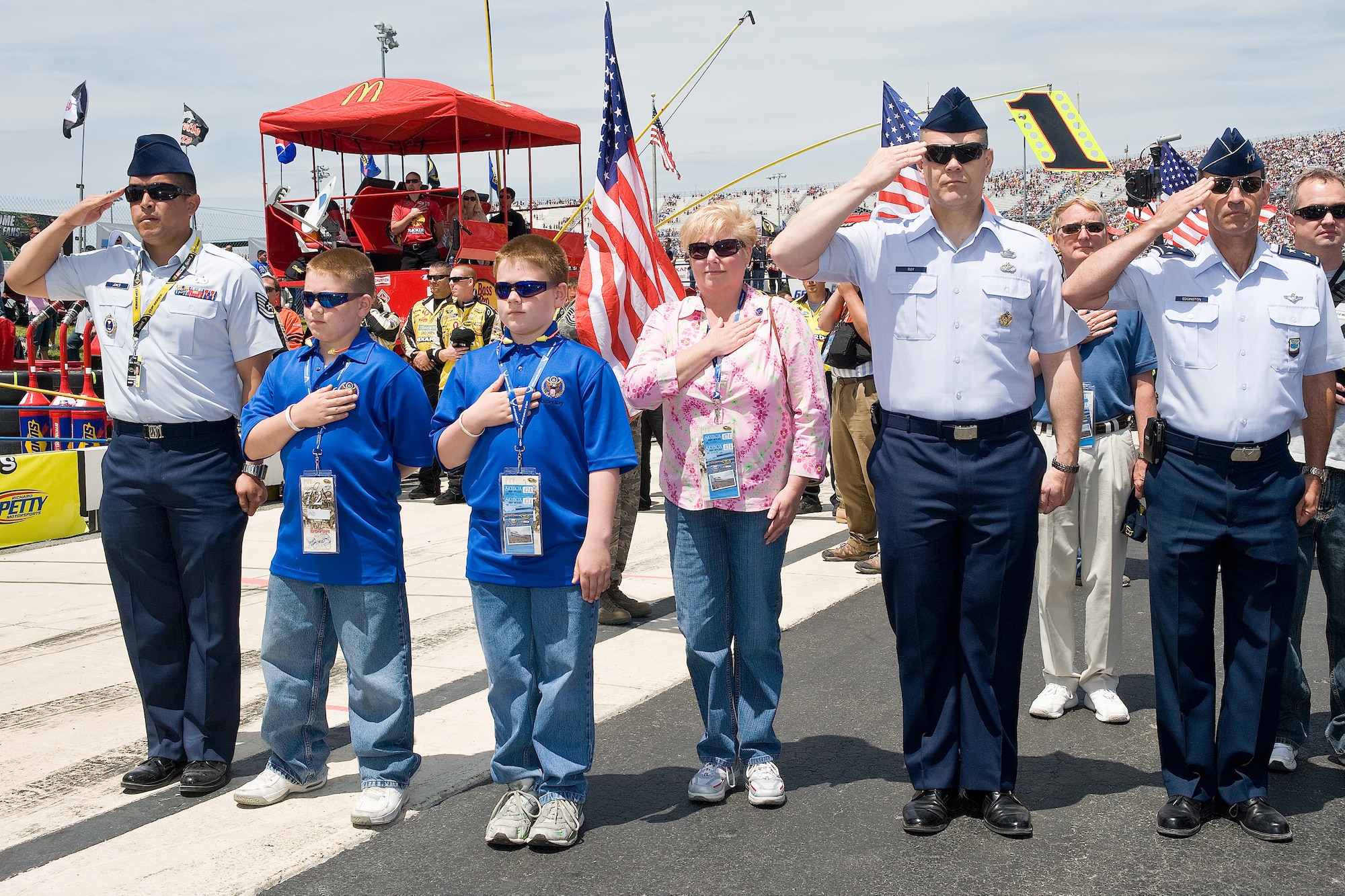 (Right) Maj. Gen. David M. Edgington, Chief of Staff, U.S. Joint Forces Command, Norfolk, Va., and Chief Master Sgt. of the Air Force James A. Roy and their guests salute the flag during the national anthem at the NASCAR Nationwide Series Race May 16. (U.S. Air Force photo/Roland Balik)