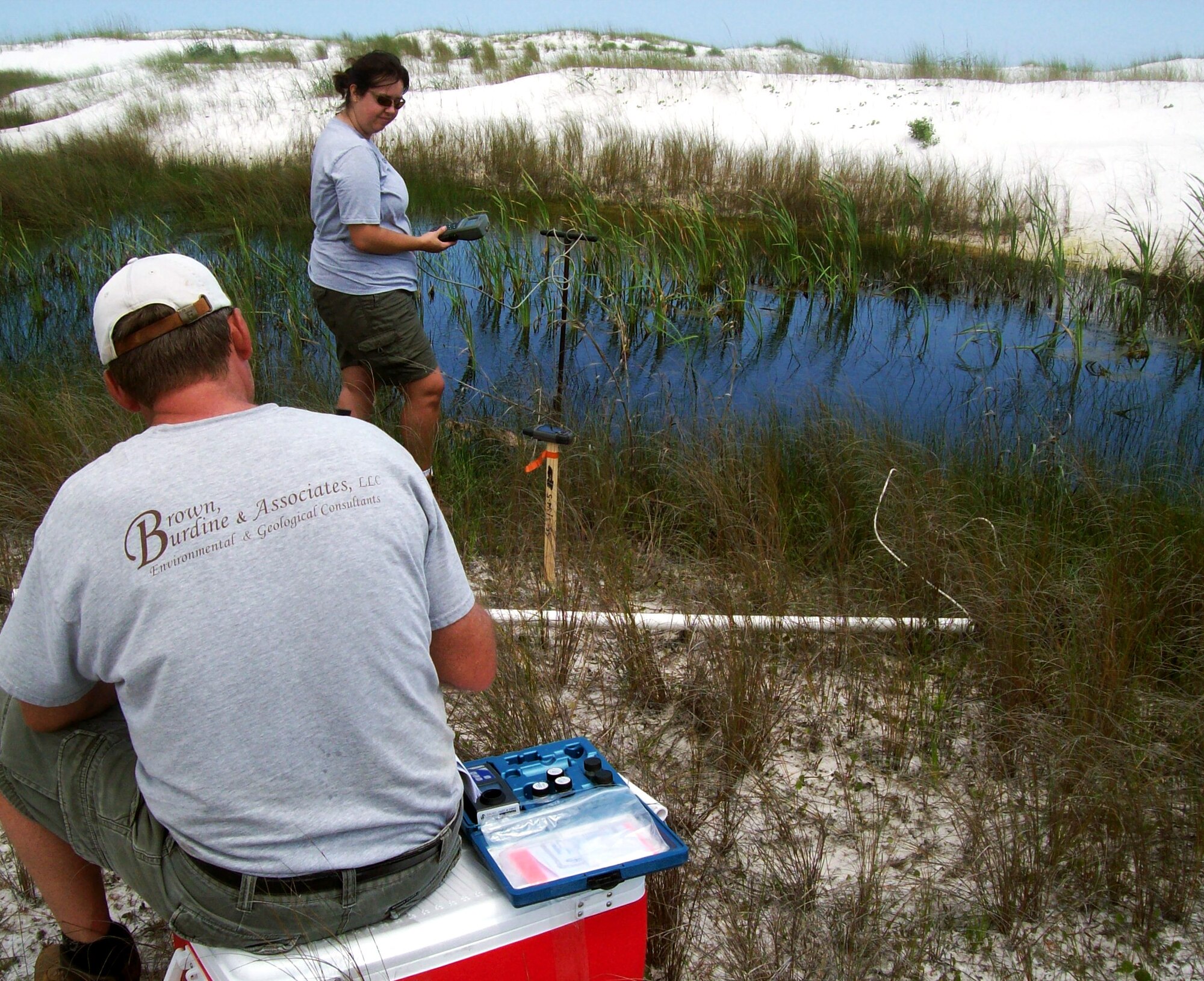 Melissa Hoover and Tony Schmucker of Brown, Burdine and Associates collect field samples from wetlands near the Eglin Beach Club on Santa Rosa Island.  Surface water and sediment samples were collected from four separate wetlands on the island. The base is collecting samples and documentation to establish a baseline condition of the 18 miles of Santa Rosa Island that Eglin controls along with the miles of shoreline along Choctawhatchee Bay to ensure the base has a strong understanding of its coastal natural resources.  (Photo by Jordan Gibson.)
