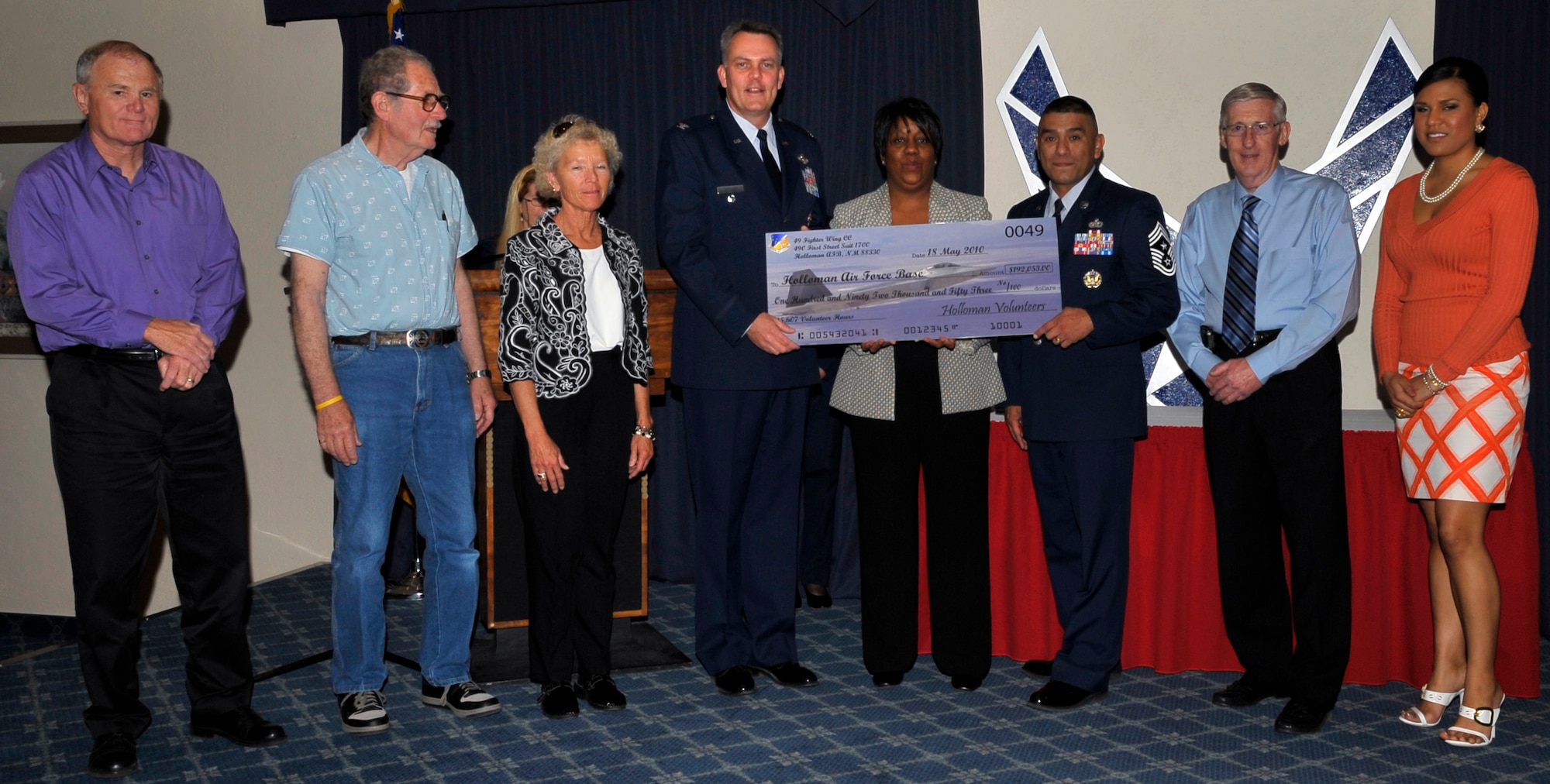 HOLLOMAN AIR FORCE BASE, N.M. -- Col. David Sullivan, 49th Fighter Wing vice commander and Chief Master Sgt. Carlos Tapia, 49th Fighter Wing command chief, receive a check from the Airman and Family Readiness Center during the annual Volunteer Recognition Ceremony May 18, 2010. The check represents 250,607 hours 152 volunteers from Team Holloman have accumulated between April 2009 and April 2010. The Volunteer Recognition Ceremony was held to show appreciation to Team Holloman volunteers. (U.S. Air Force photo by Airman 1st Class Joshua Turner / Released)