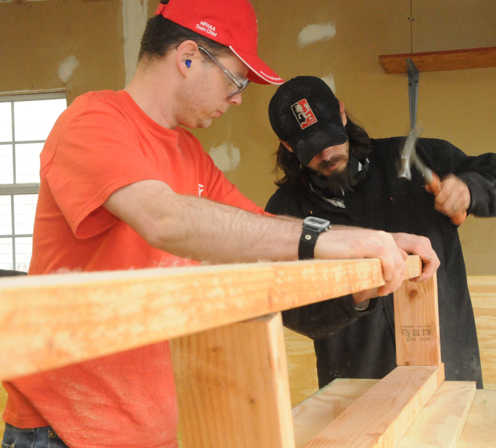 ALTUS AIR FORCE BASE, Okla.--Staff Sgt. Richard Moutray, 97th Logistics Readiness Squadron, and Richard Ball, community volunteer, prepare wood formations at the local Habitat for Humanity workshop April 16. These wooden structures will help to support the new Habitat for Humanity home that is being built by base and community volunteers. (U.S. Air Force photo / Senior Airman Cherice Bryant / Release 97th Air Mobility Wing-Public Affairs)
