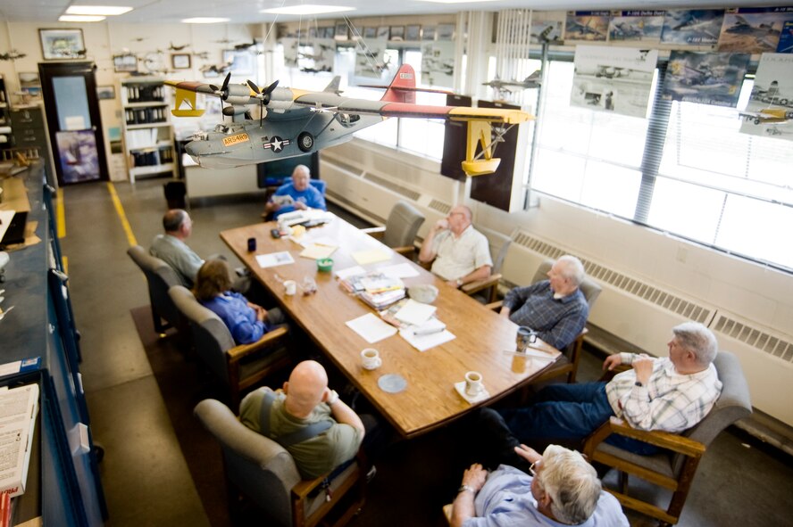 PB-Y Catalina restoration crew members take a break beneath a model airplane.  THe PB-Y came to McChord Field in 1988 with its wings sawed off, and has since been restored almost completely.  (U.S. Air Force photo/Abner Guzman)

