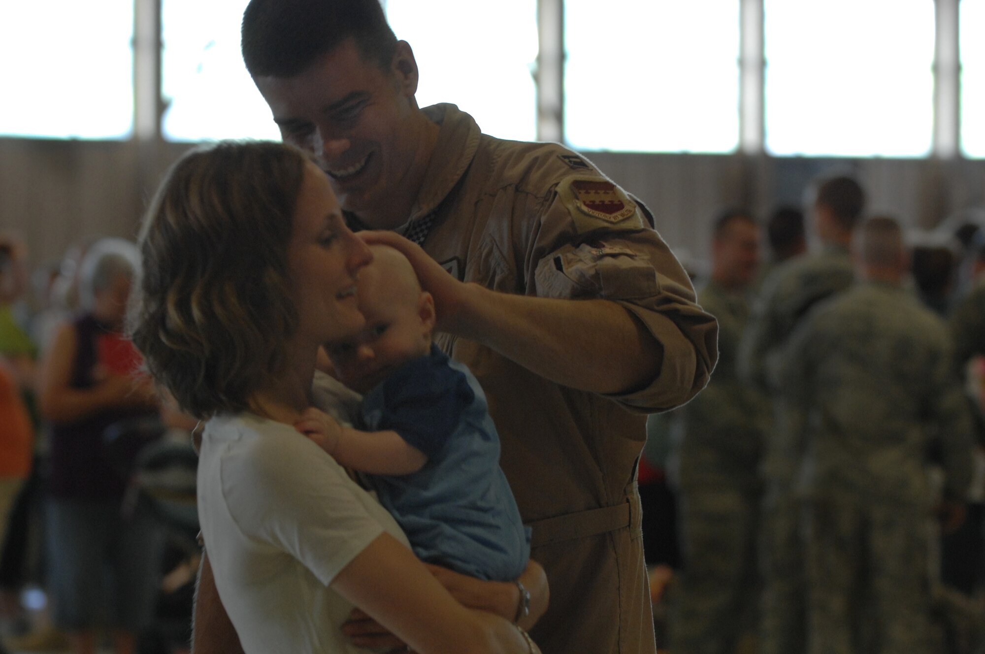 U.S. Air Force Capt. Aaron Weedman, 55th Fighter Wing pilot has a few final moments with his wife Carrie and son Mason Weedman at Hangar 1200 here, May 15, 2010. Nearly 300 Airmen from the 55th Fighter Squadron and 55th Aircraft Maintenance Unit ?Shooters,? as well as 20th Component Maintenance and Equipment Maintenance Airmen deployed to Iraq. (U.S. Air Force photo/ Airman 1st Class Alexandria Mosness)