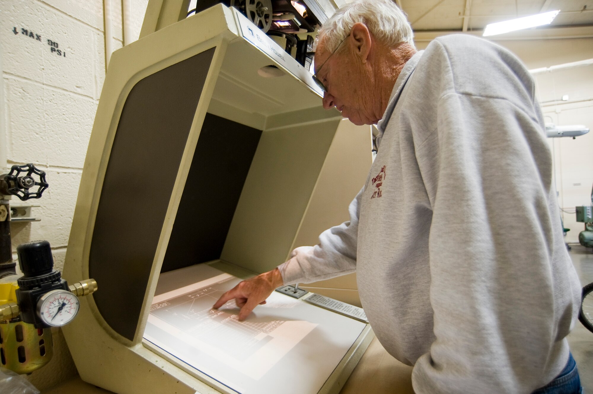 Senior Master Sgt. (ret.) Rod Wilson uses microfishe to scan original B-18 blueprints for guidance in building a radio table.  Sergeant Wilson, who has been part of the B-18 restoration crew for twelve years, is conisdered one of the "new" guys.  The crew has been restoring the aircraft for more than twenty years.  (U.S. Air Force Photo/Abner Guzman)