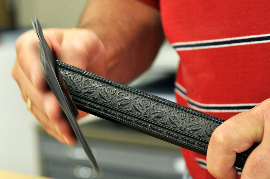 OFFUTT AIR FORCE BASE, Neb. -- Loren Storey, 55th Force Support Squadron, sands down the edge of a wooden frame inside the Arts and Crafts Center here May 18. The facility offers pottery and stained glass classes and offers the Offutt community a place to obtain retail framing and engraving services. U.S. Air Force Photo by Charles Haymond