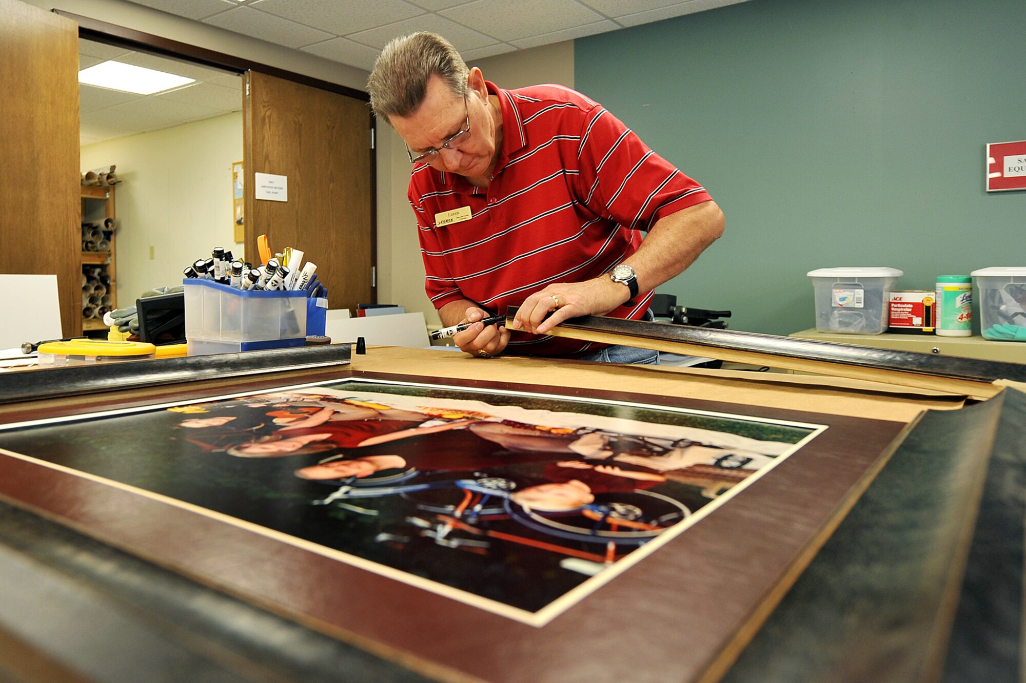OFFUTT AIR FORCE BASE, Neb. -- Loren Storey, 55th Force Support Squadron, colors the edges of a wood frame inside the Arts and Craft Center here May 18. The facility offers pottery and stained glass classes and offers the Offutt community a place to obtain retail framing and engraving services. U.S. Air Force Photo by Charles Haymond 