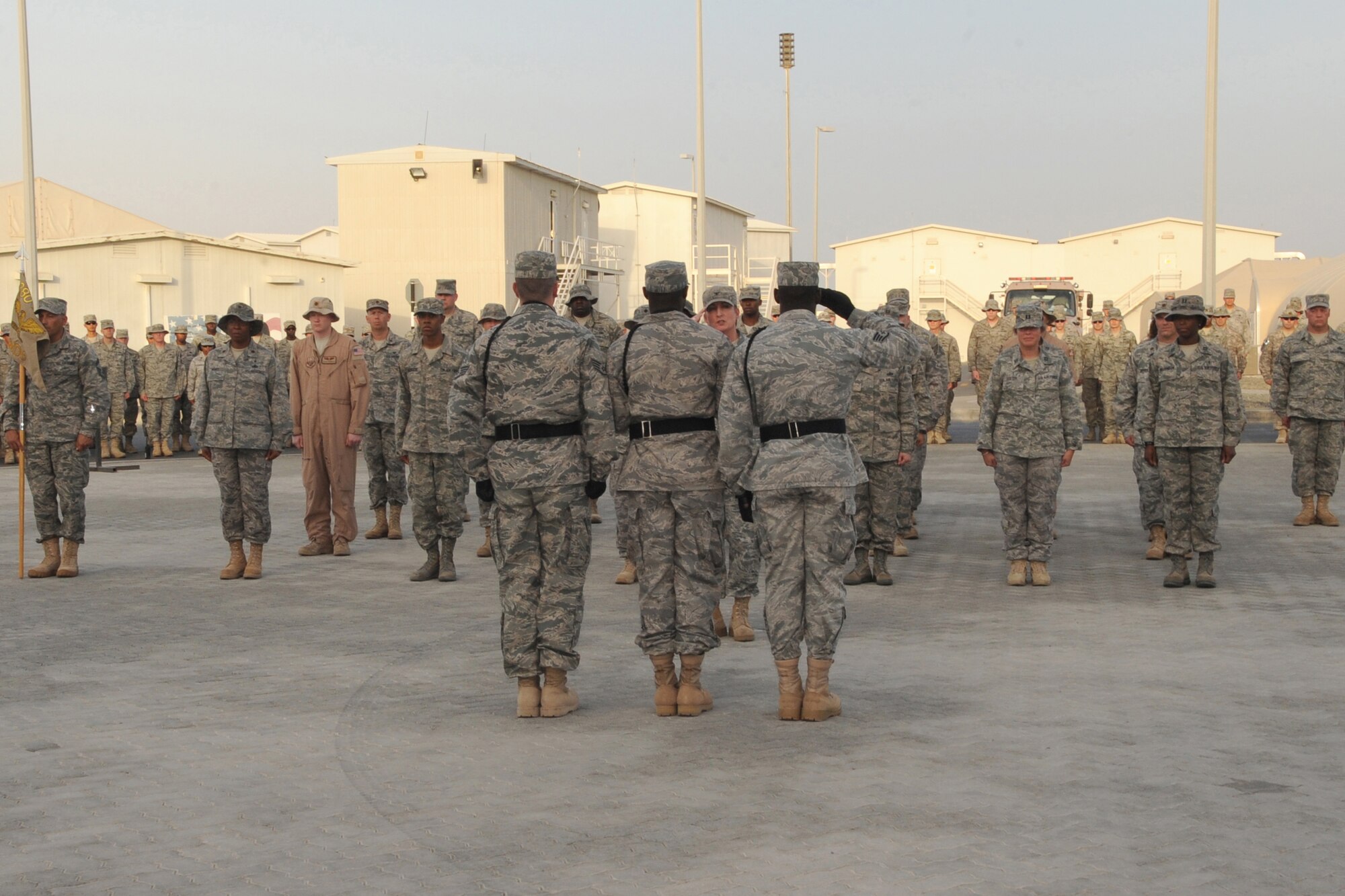 Members of the 380th Air Expeditionary Wing Honor Guard along with members from across the 380th AEW perform retreat, a ceremony that marks the end of the duty day, at an undisclosed location in Southwest Asia on May 14, 2010.  Airmen from across the wing join every week to pay their respects. The 380th AEW supports Operations Iraqi Freedom and Enduring Freedom and the Combined Joint Task Force-Horn of Africa. Its comprised of four groups and 12 squadrons and the wing's deployed mission includes air refueling, surveillance and reconnaissance in support of overseas contingency operations in Southwest Asia.(U.S. Air Force photo/Senior Airman Jenifer H. Calhoun/Released)