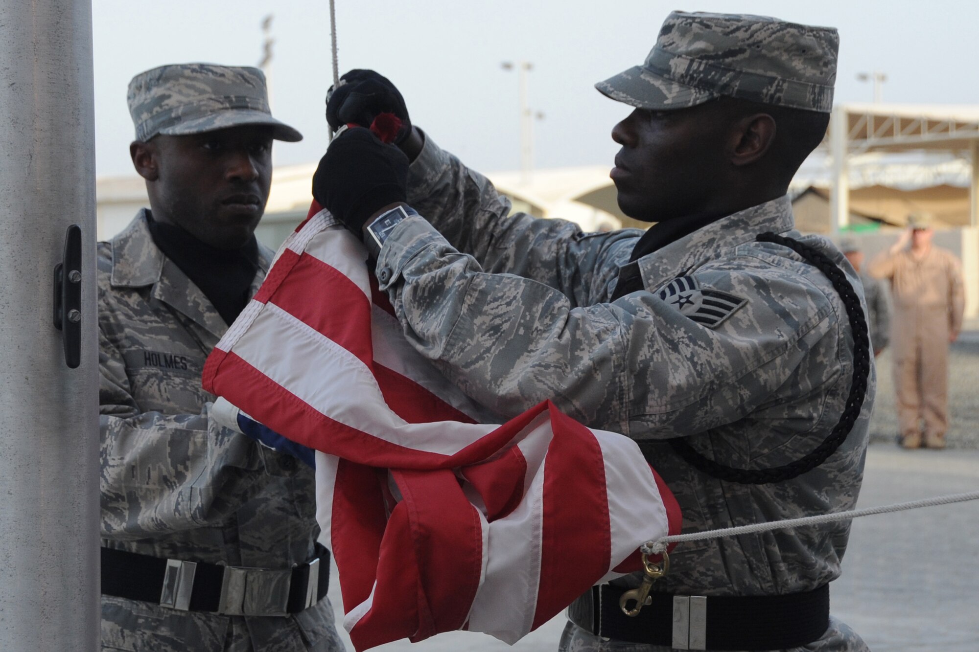 Members of the 380th Air Expeditionary Wing Honor Guard along with members from across the 380th AEW perform retreat, a ceremony that marks the end of the duty day, at an undisclosed location in Southwest Asia on May 14, 2010.  Airmen from across the wing join every week to pay their respects. The 380th AEW supports Operations Iraqi Freedom and Enduring Freedom and the Combined Joint Task Force-Horn of Africa. Its comprised of four groups and 12 squadrons and the wing's deployed mission includes air refueling, surveillance and reconnaissance in support of overseas contingency operations in Southwest Asia.(U.S. Air Force photo/Senior Airman Jenifer H. Calhoun/Released)
