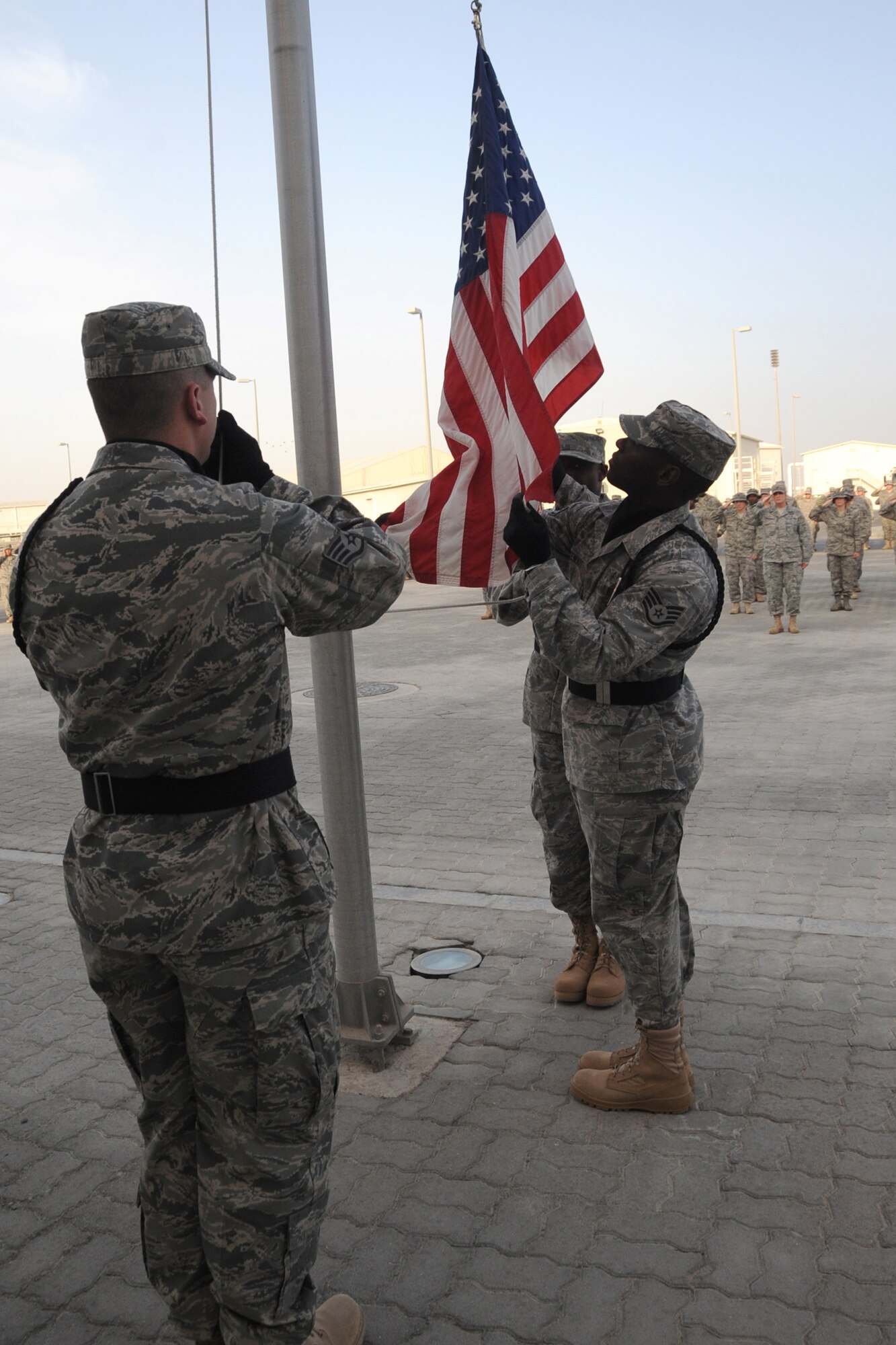 Members of the 380th Air Expeditionary Wing Honor Guard along with members from across the 380th AEW perform retreat, a ceremony that marks the end of the duty day, at an undisclosed location in Southwest Asia on May 14, 2010.  Airmen from across the wing join every week to pay their respects. The 380th AEW supports Operations Iraqi Freedom and Enduring Freedom and the Combined Joint Task Force-Horn of Africa. Its comprised of four groups and 12 squadrons and the wing's deployed mission includes air refueling, surveillance and reconnaissance in support of overseas contingency operations in Southwest Asia.(U.S. Air Force photo/Senior Airman Jenifer H. Calhoun/Released)