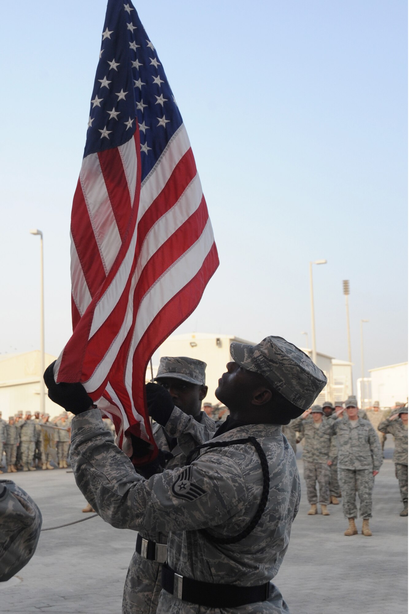 Members of the 380th Air Expeditionary Wing Honor Guard along with members from across the 380th AEW perform retreat, a ceremony that marks the end of the duty day, at an undisclosed location in Southwest Asia on May 14, 2010.  Airmen from across the wing join every week to pay their respects. The 380th AEW supports Operations Iraqi Freedom and Enduring Freedom and the Combined Joint Task Force-Horn of Africa. Its comprised of four groups and 12 squadrons and the wing's deployed mission includes air refueling, surveillance and reconnaissance in support of overseas contingency operations in Southwest Asia.(U.S. Air Force photo/Senior Airman Jenifer H. Calhoun/Released)