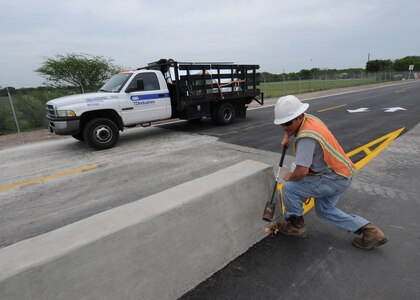 A truck enters the recently renovated south gate at Randolph Air Force Base, Texas as construction workers put the finishing touches to the project April 12. The gate was closed to traffic while the project was underway. (U.S. Air Force photo by David Terry)