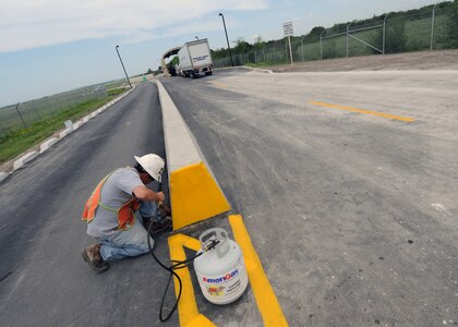 A truck enters the recently renovated south gate at Randolph Air Force Base, Texas, as construction workers put the finishing touches on the project April 12. The gate was closed to traffic while the project was underway. (U.S. Air Force photo by David Terry)
