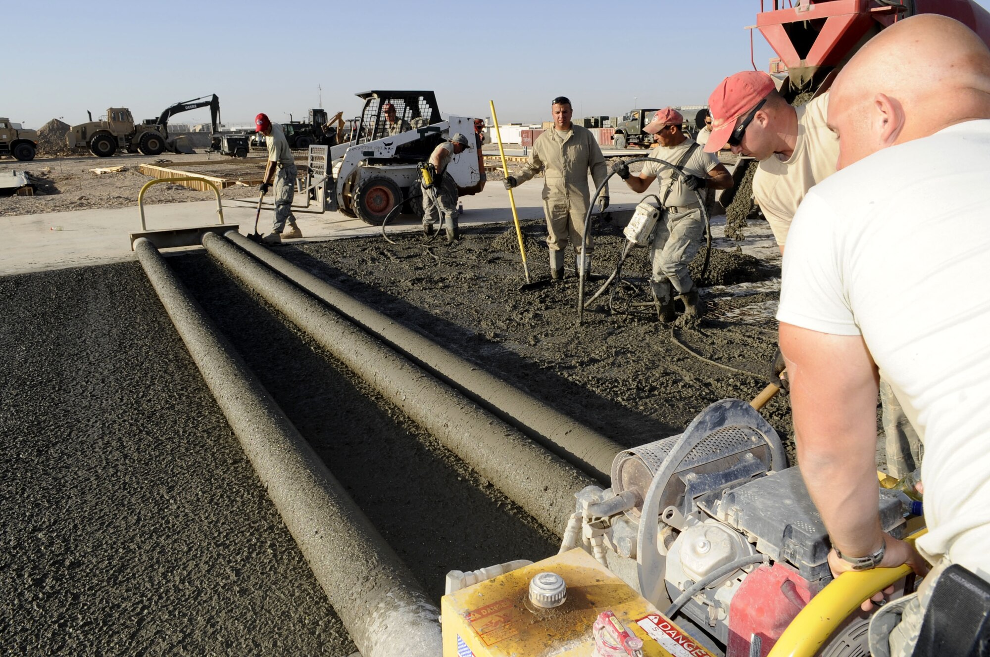 Members of the 809th Expeditionary Red Horse Squadron run a roller screen to smooth the concrete as it is shaped May 15 on Kandahar Airfield. (U.S. Air Force photo by Senior Airman Nancy Hooks/Released)
