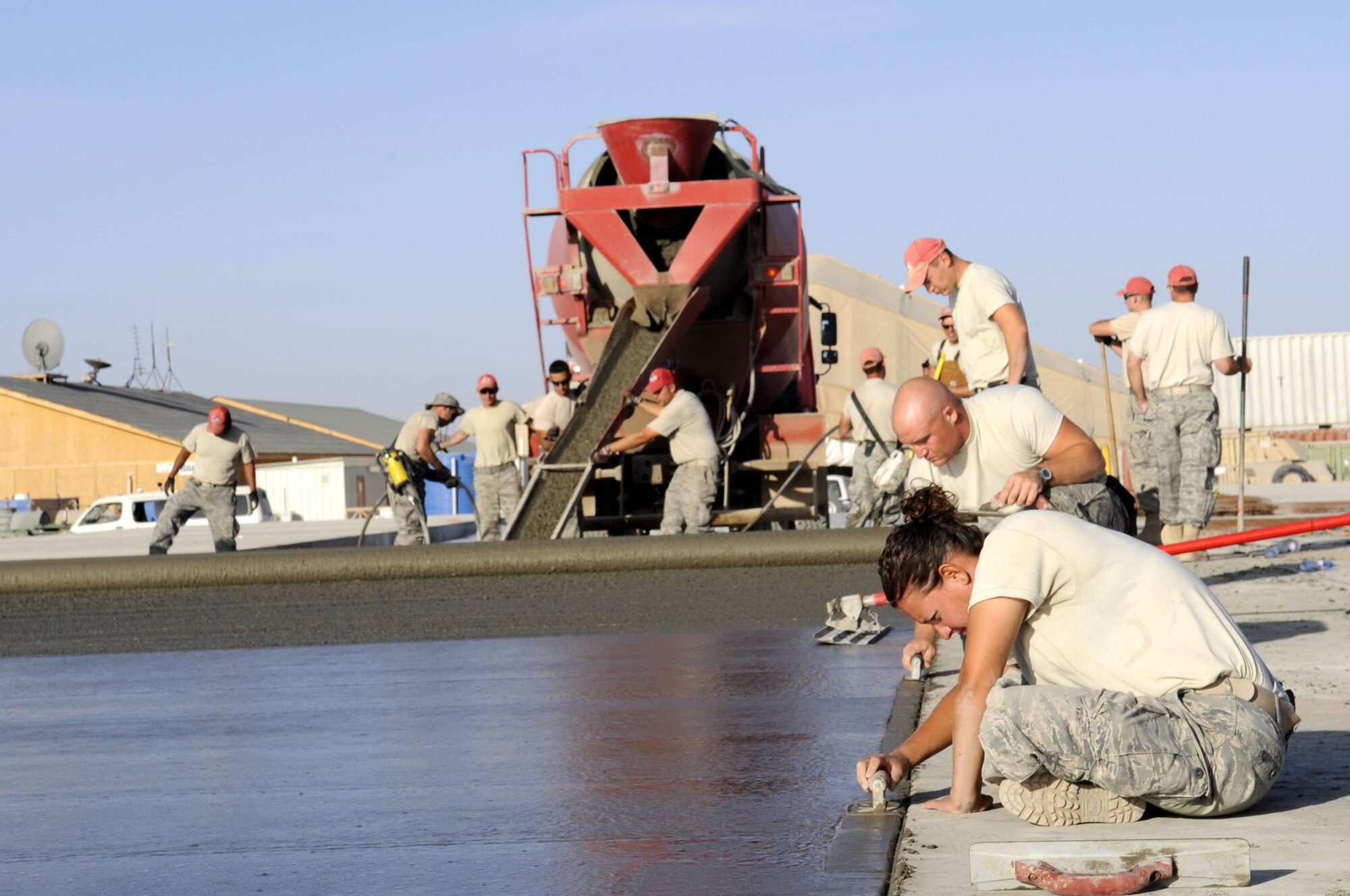 Other members of the 809th Expeditionary Red Horse Squadron smooth newly-poured concrete slabs by hand. The unit is known for being able to complete large construction projects quickly. (U.S. Air Force photo by Senior Airman Nancy Hooks/Released)
