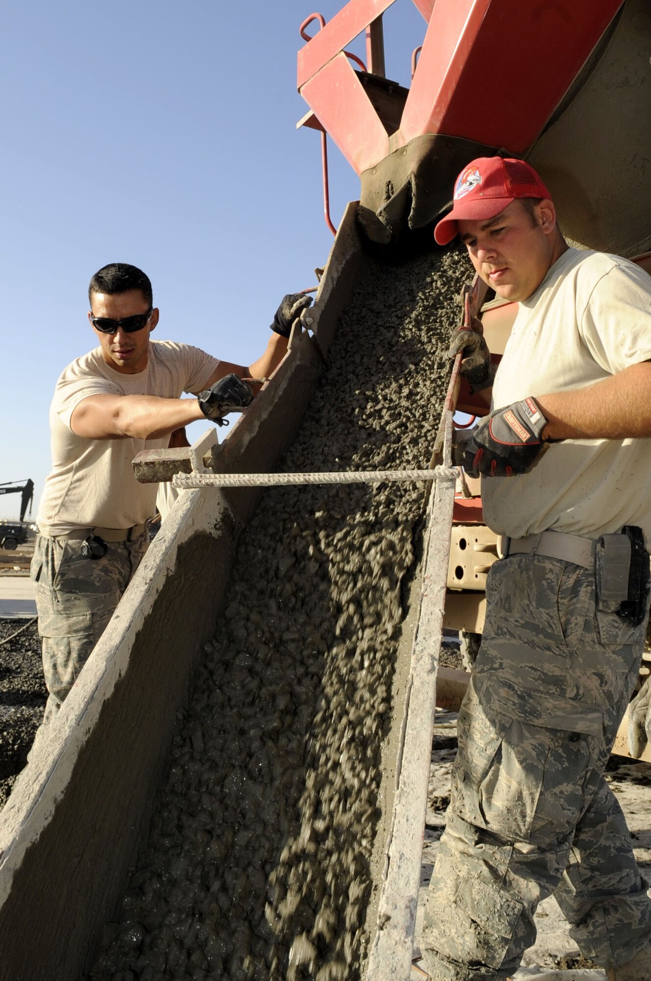 Airmen assigned to the 809th Expeditionary Red Horse Squadron guide the chute as concrete is poured into the steel forms, creating large area maintenance shelter pads May 15 on Kandahar Airfield. The LAMS pads will be used for aviation maintenance. (U.S. Air Force photo by Senior Airman Nancy Hooks/Released)

