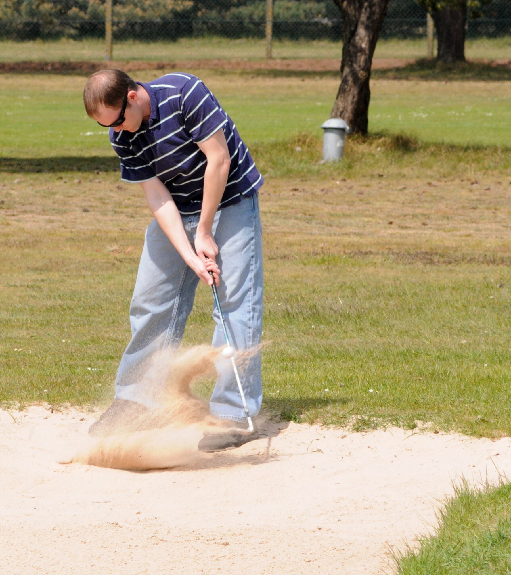 RAF Mildenhall, England -- Justin Gazda, 352th Operations Support Squadron, plays his second shot out of the trap at the sixth hole during Intramural Golf at Breckland Pines Golf Club, May. 8 The ball finished 6 feet from the hole and his playing partner sank the putt for a par. (U. S. Air Force photo by Gary Rogers)