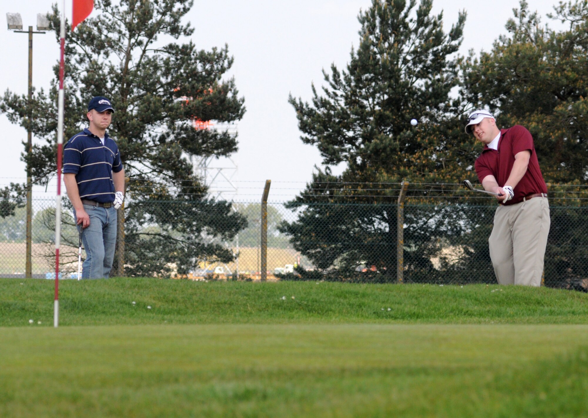 RAF Mildenhall, England -- Brian Szarek, 100th Maintenance Squadron, plays a delicate chip on to the second green while playing partner Devon Ellis watches on during Intramural Golf at Breckland Pines Golf Club, May. 8. (U. S. Air Force photo by Gary Rogers)