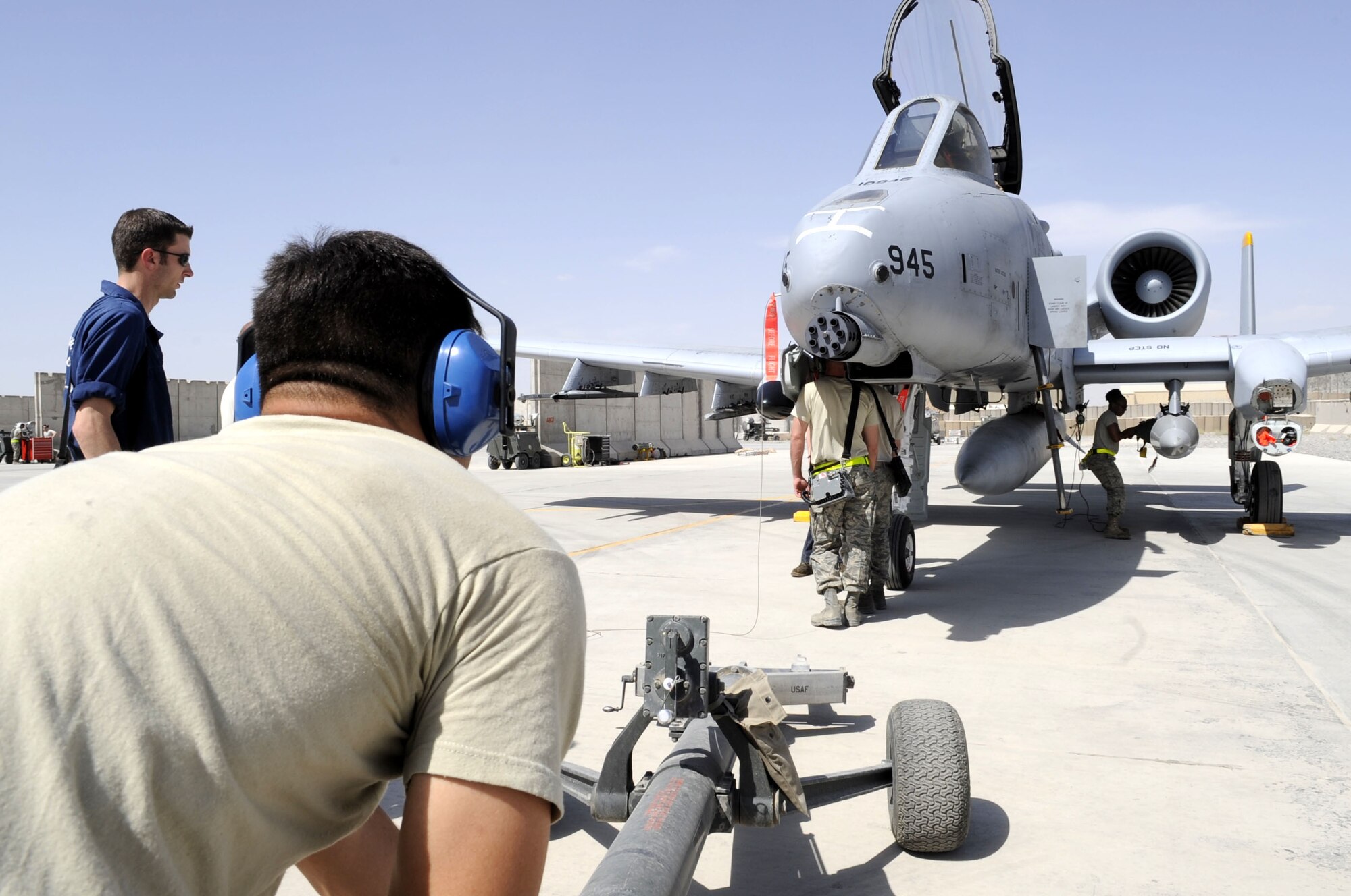Members of the 81st Expeditionary Aircraft Maintenance Squadron prepare to set a toe bar to the nose wheel of an A-10 Thunderbolt II to push the aircraft back into parking position May 11.  Within a two week period a total of 12 jets arrived on Kandahar Airfield.  (U.S. Air Force photo by Senior Airman Nancy Hooks/Released)
