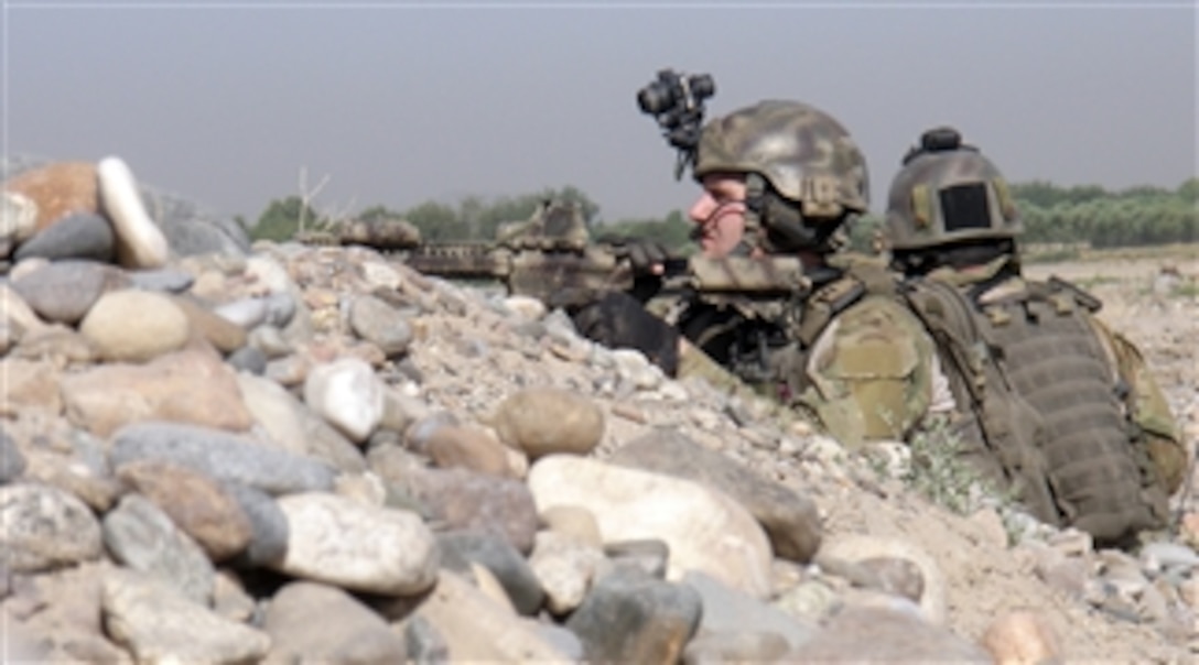 Service members on a joint Afghan, International Security Assistance Force mission secure an area while in pursuit of insurgents north of the village of Mian in the Kandahar district of Afghanistan on May 13, 2010.  