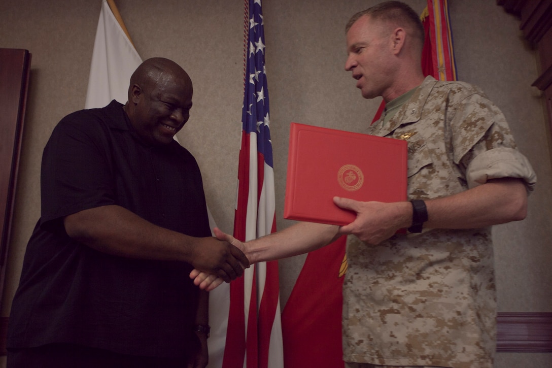 Andrew Samuels, station anti-terrorism officer, recieves the Security and Law Enforcement Civilian Marine of the Year Award from Col. Michael O’Halloran, station commanding officer here May 14. “Mr. Samuels’ anti-terrorism/force protection programs have been an integral part in ensuring MCAS Iwakuni is able to perform both it’s day-to-day and wartime missions,” said O’Halloran in a letter of nomination.