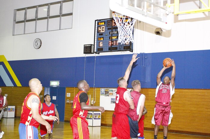 Chase Dariso, sophomore at Matthew C. Perry High School and player for the IYAOYAS, puts up a shot as Tommy R. Bryan III, player for the Fil-Am team, prepares to block or rebound the ball during a 2010 Intramural Basketball game at IronWorks gym May 19. The Fil-Am intramural basketball team came out victorious over the IYAOYAS 47-36.