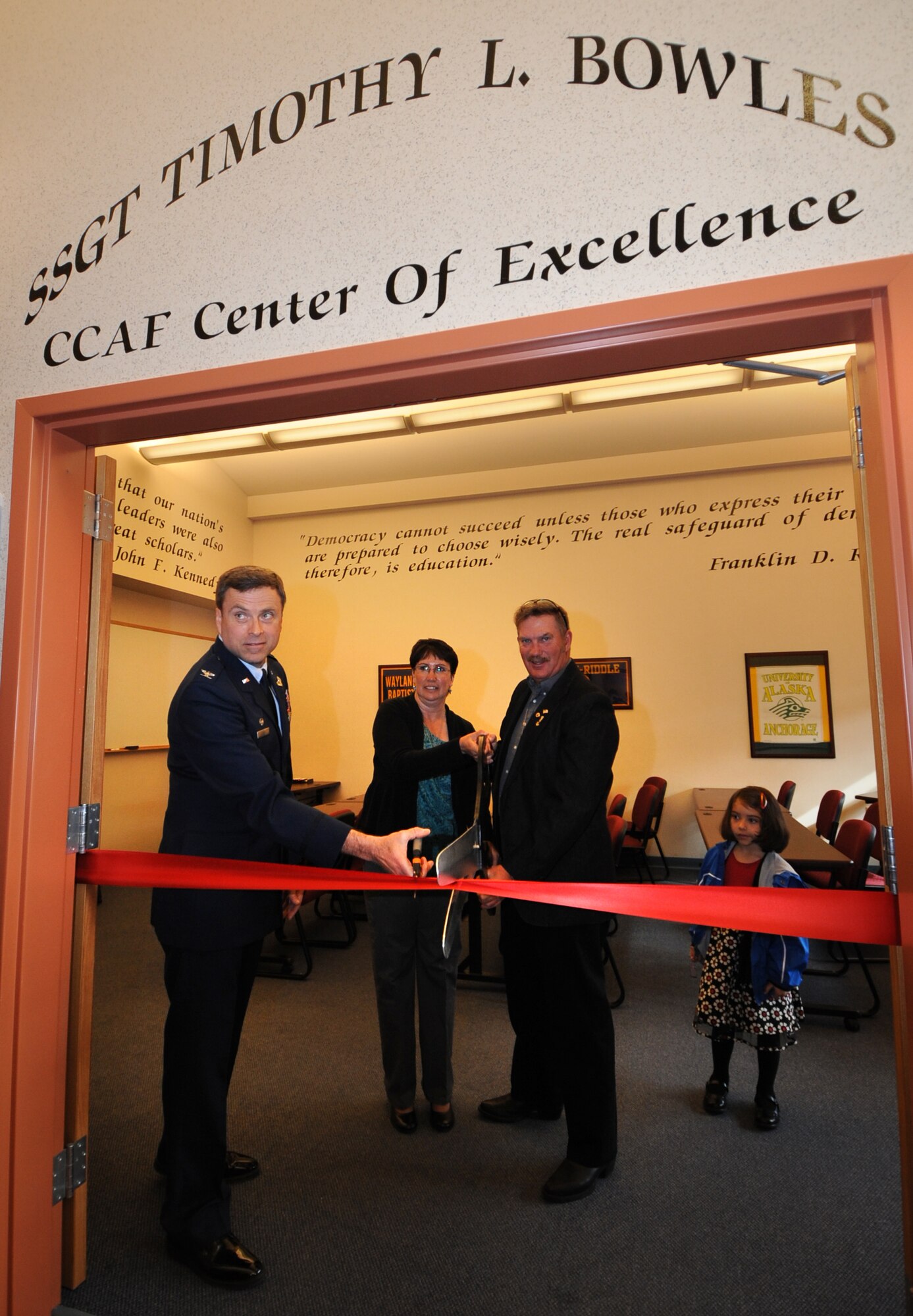 ELMENDORF AIR FORCE BASE, Alaska -- Col. Mark Chance joins Master Sgt. (Ret.) Louis and Lisa Bowles in cutting the ribbon to the Staff Sgt. Timothy L. Bowles Community College of the Air Force Center for Excellence  room in the Wired Cafe. This room was dedicated to their son, Sergeant Bowles, May 19. Sergeant Bowles was killed while deployed to Afghanistan in 2009. "The best way to honor Sergeant Bowles memory is to use this room," said Staff Sergeant John Reddick. Colonel Chance is the 3rd Mission Support Group commander and Sergeant Reddick is with the 3rd Logistics Readiness Squadron and a close friend. (Air Force Photo by Senior Airman Cynthia Spalding)