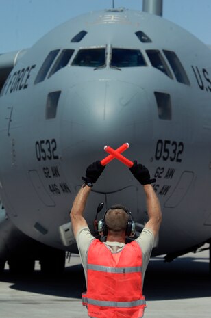 Tech. Sgt. Scott Krumbholz marshals a C-17 Globemaster III into its parking spot at Nellis Air Force Base following a Mobility Air Forces Exercise, May 19. Approximately 40 C-17 Globemaster III and C-130 Hercules aircraft from Air Force bases in Alaska and the Continental United States met over the Nevada Test and Training Range to conduct air and ground operations as part of the bi-annual exercise which is planned and executed by students assigned to the U.S. Air Force Weapons School. Sergeant Krumbholz is assigned to the 62nd Aircraft Maintenance Squadron, McChord AFB, Wash. (U.S. Air Force photo by Master Sgt. Kevin J. Gruenwald)


